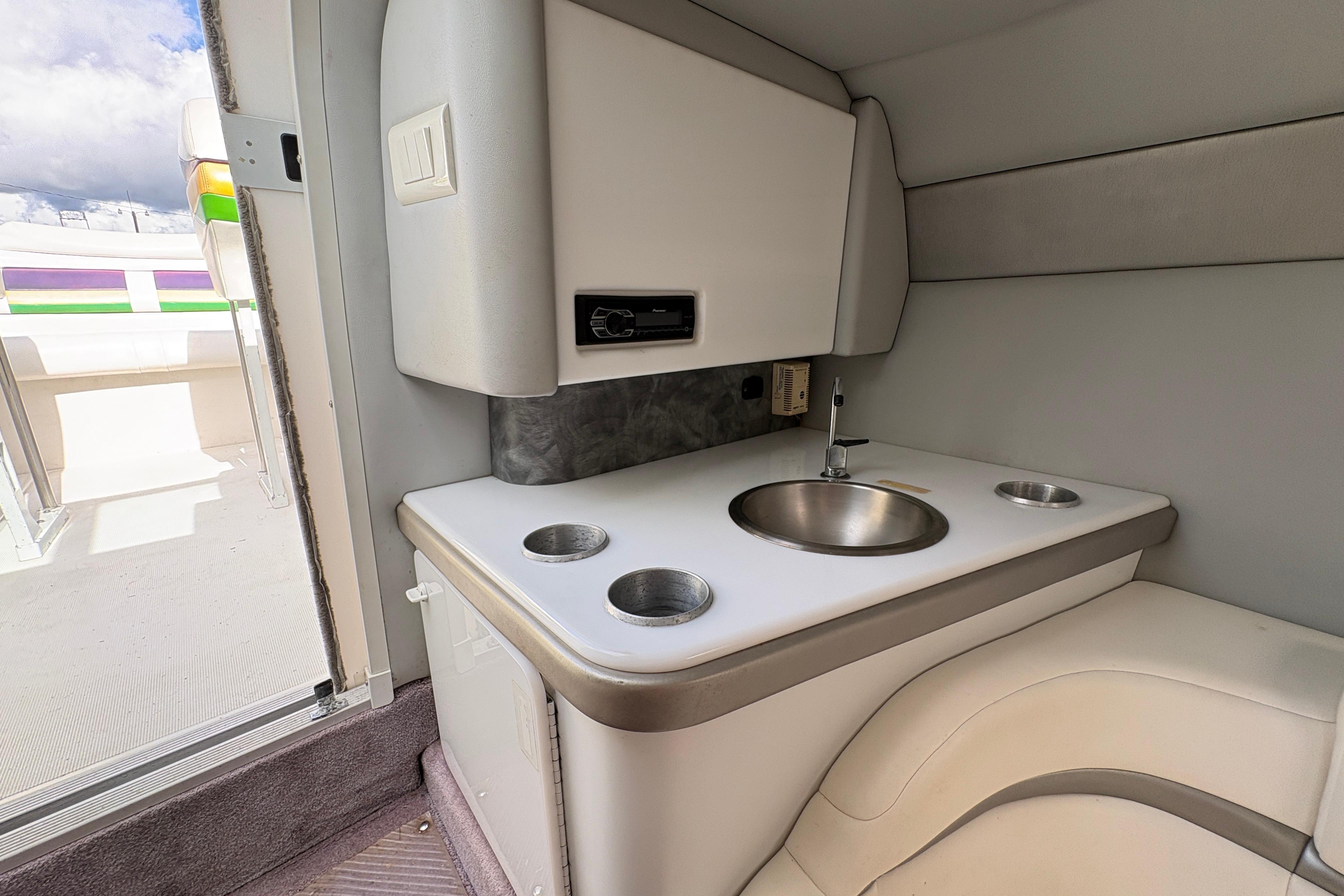 Interior of a 2002 Formula 292 FASTech boat featuring a compact sink and seating area.