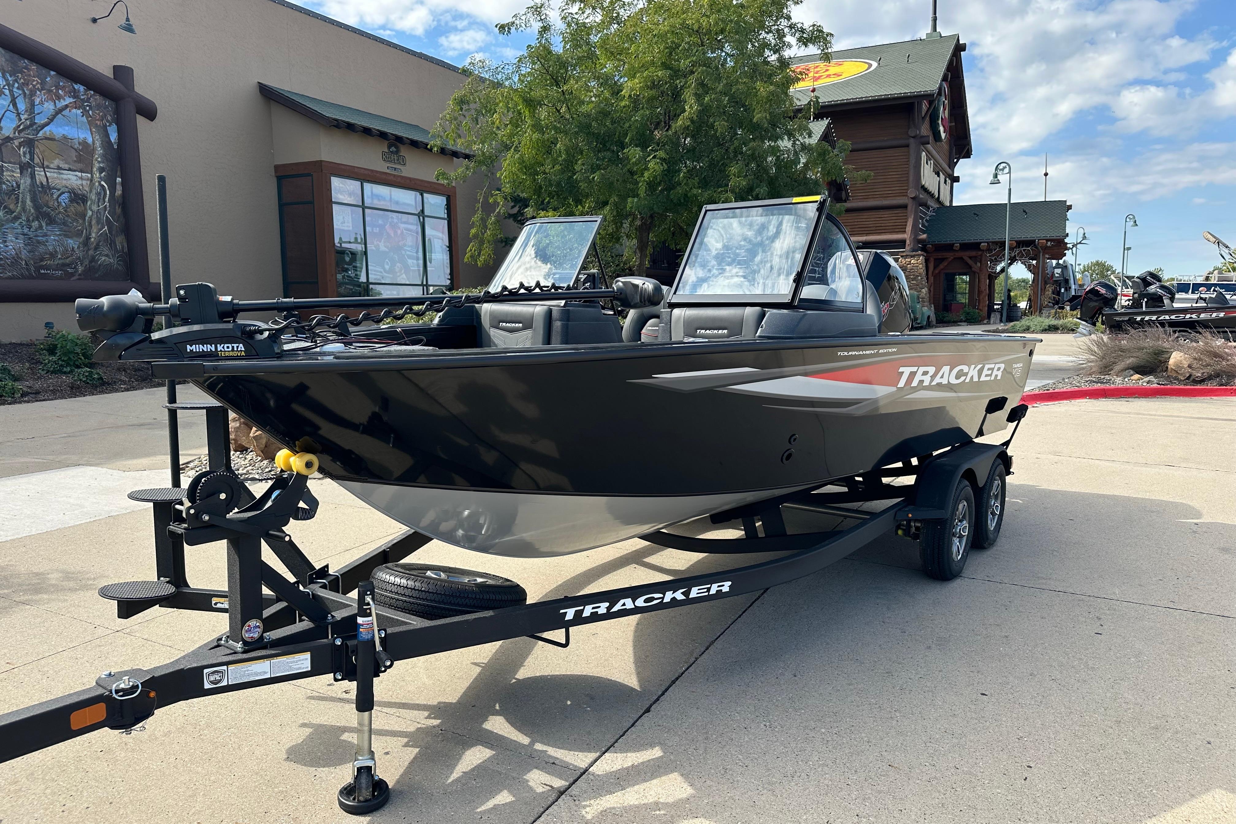 2026 Tracker Targa V-19 WT boat on trailer, parked outdoors near a building.