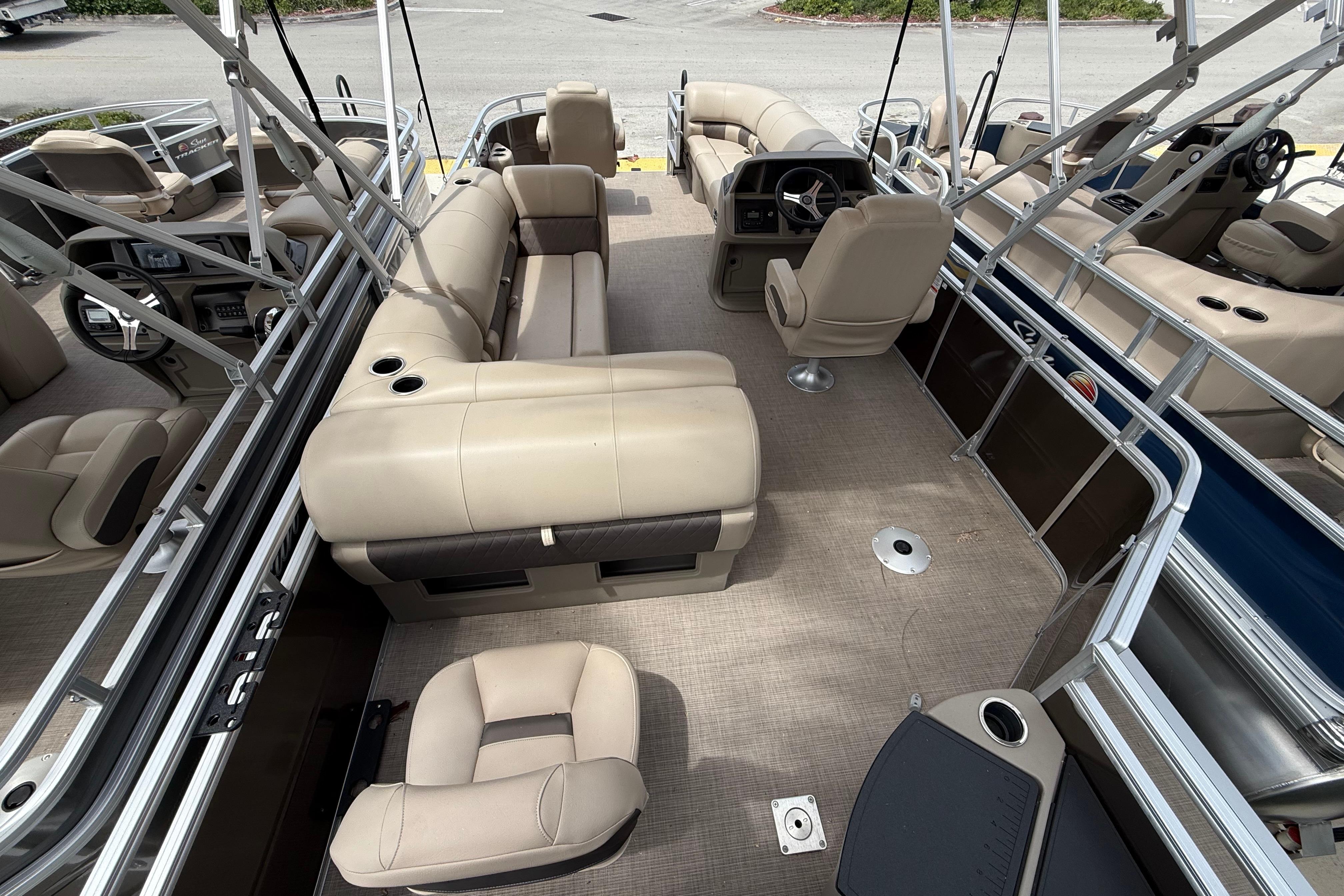 2025 Sun Tracker SportFish 20 DLX pontoon boat interior with beige seating and steering console.