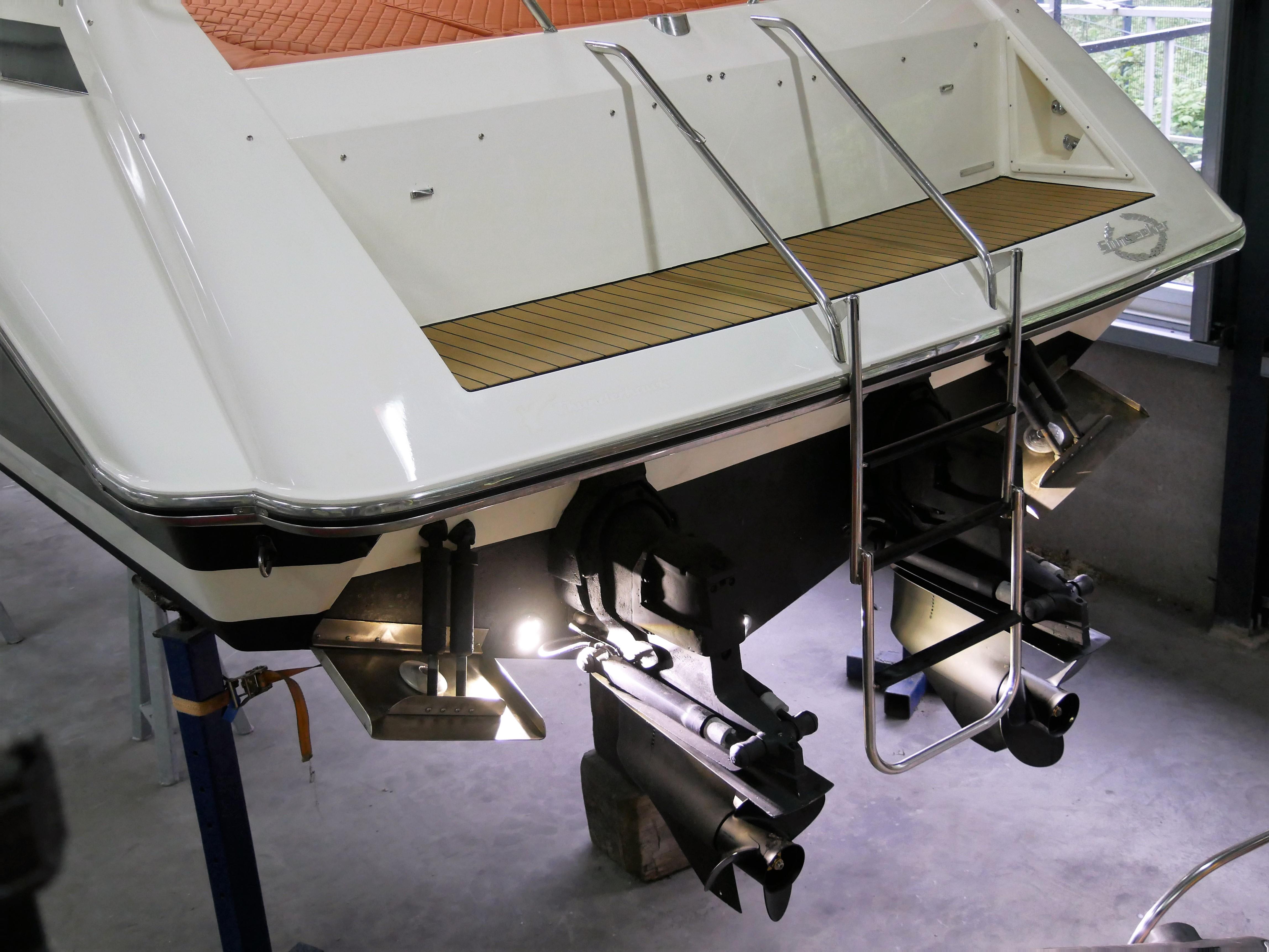 1991 Sunseeker Thunderhawk 43 boat stern with ladder and propellers in a workshop.