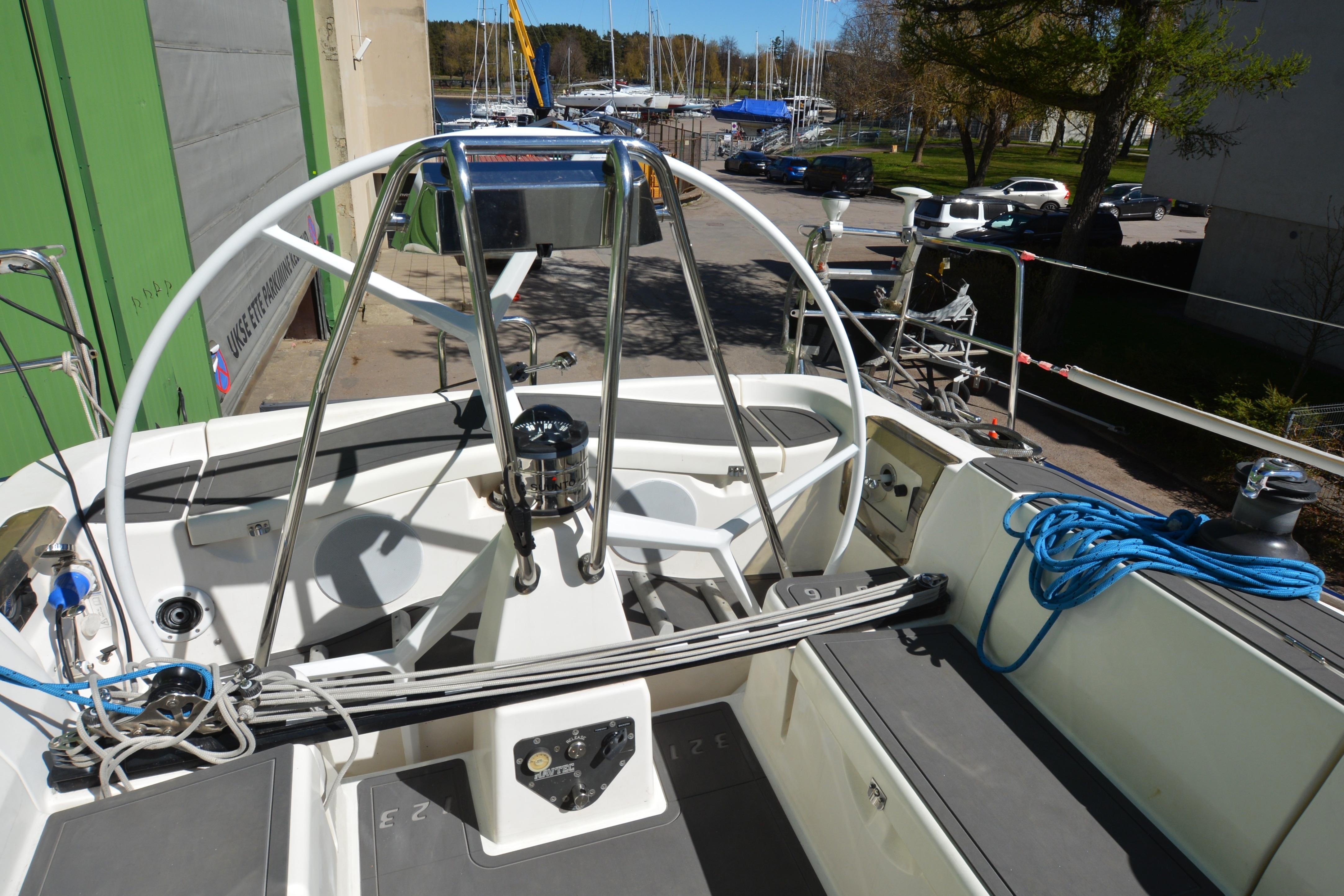 2004 X-Yachts X-46 sailboat cockpit with steering wheel and rigging, docked at marina.