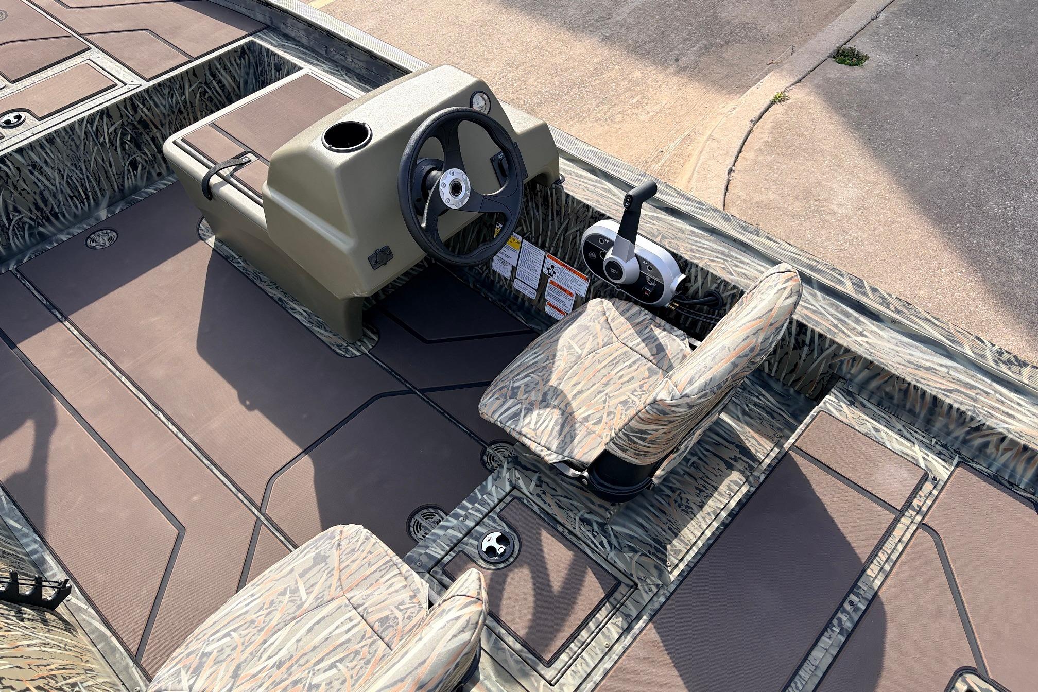 2026 Tracker Grizzly 1754 SC boat interior with steering console and camo seats.