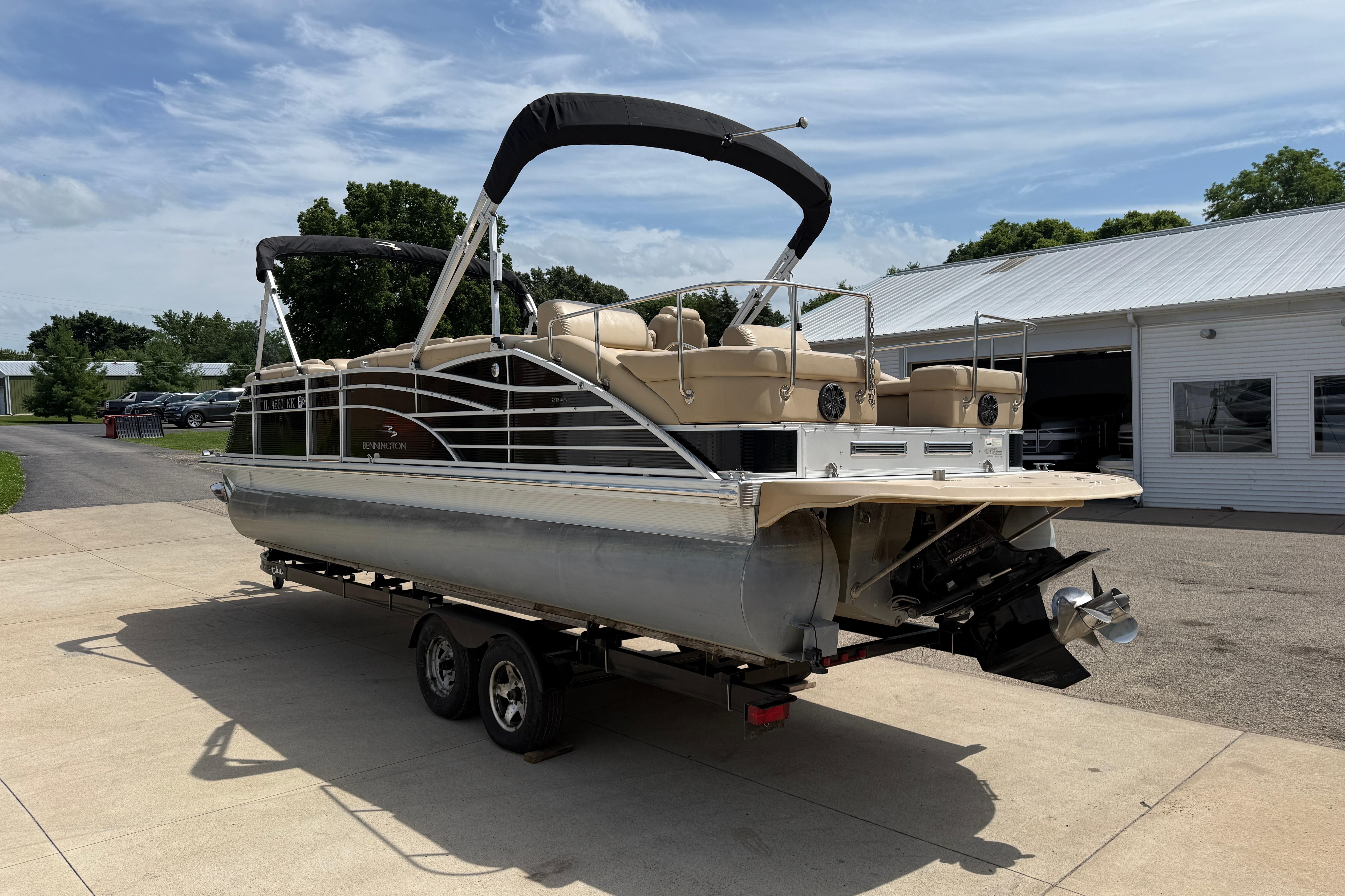 2011 Bennington 2575QCW I/O pontoon boat on trailer, parked outdoors.