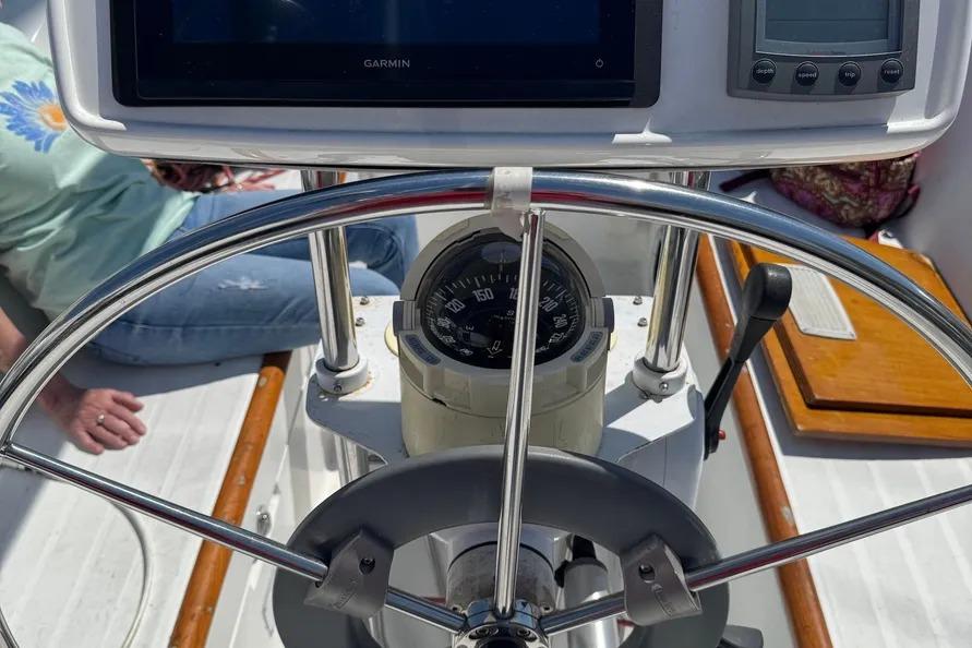 Steering wheel and navigation instruments on a 2000 Beneteau Oceanis 321 sailboat.