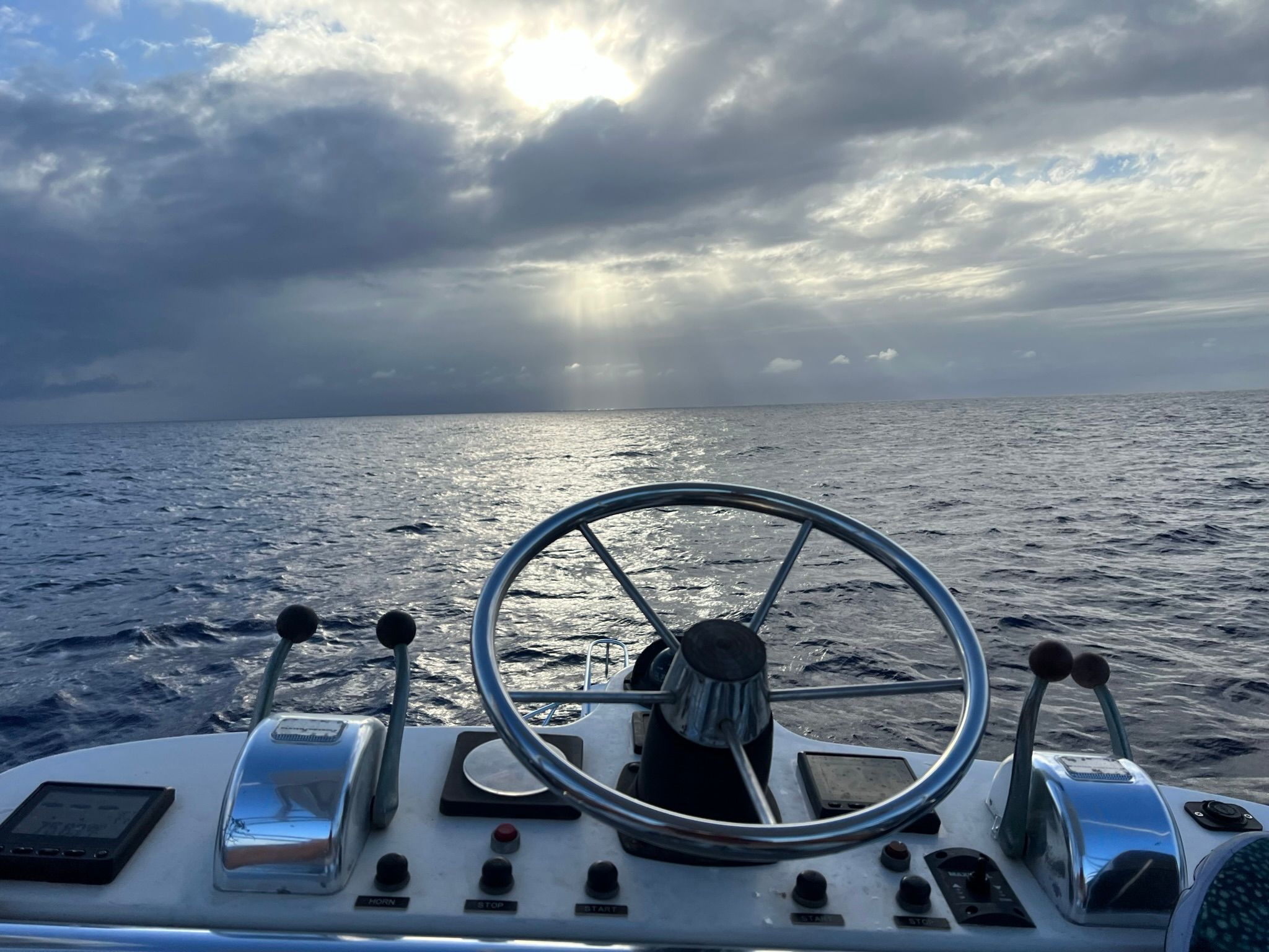 The helm of a 2001 Blackfin Combi overlooking the open sea under a cloudy sky.