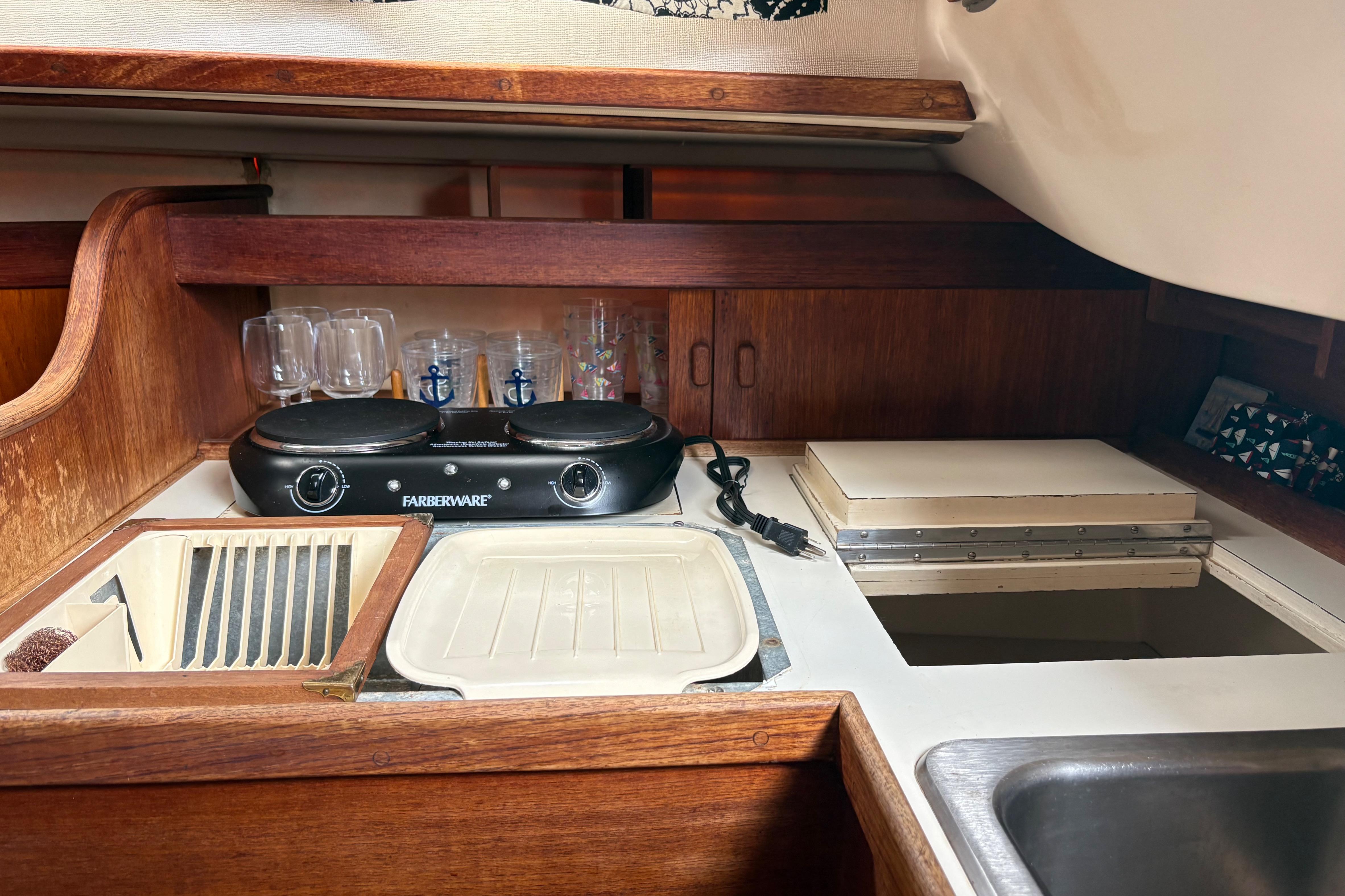 1981 Sabre 31 yacht galley with stove, sink, and wooden cabinetry.