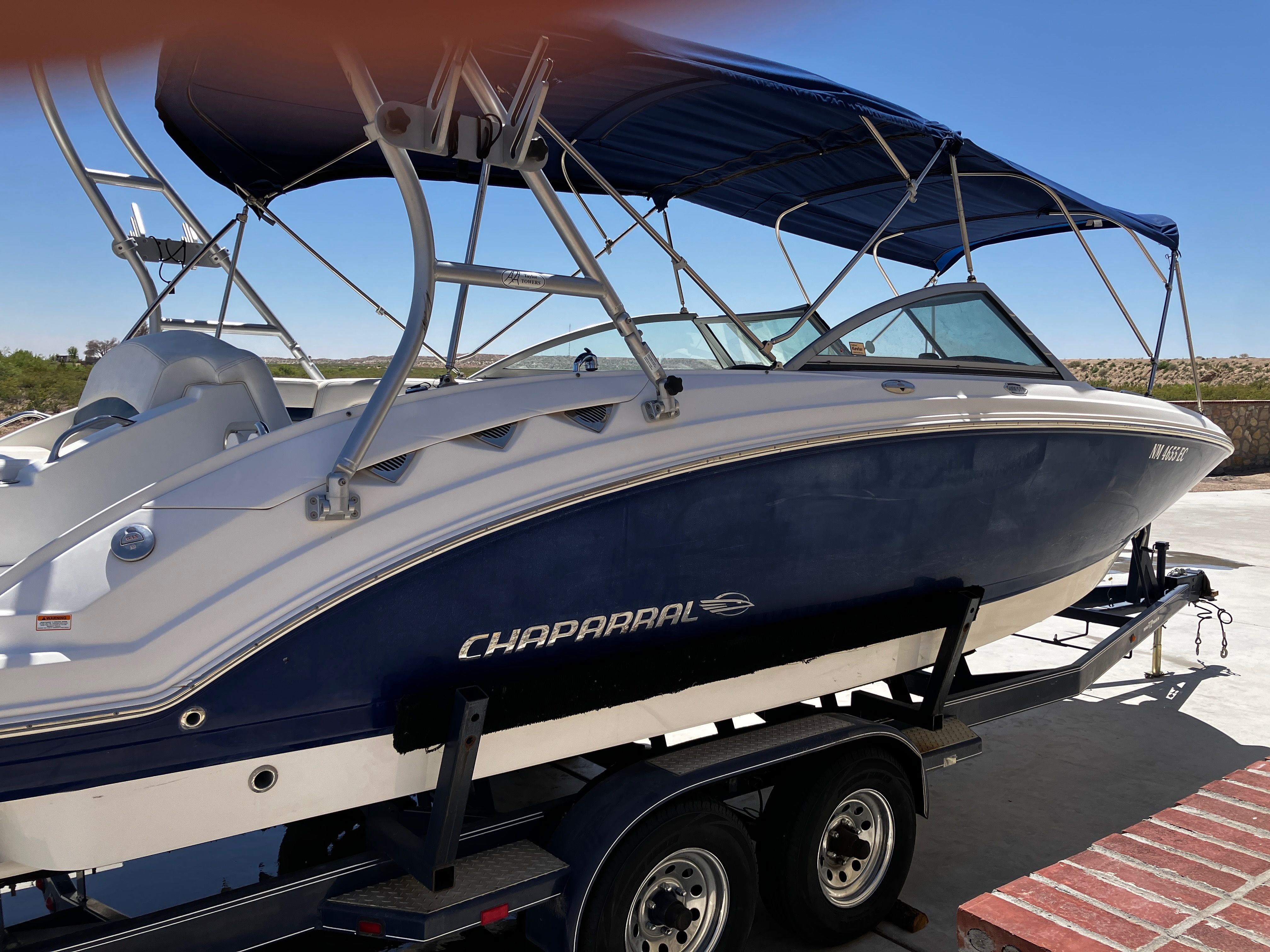 2008 Chaparral Sonesta boat on trailer, blue hull, sunshade.