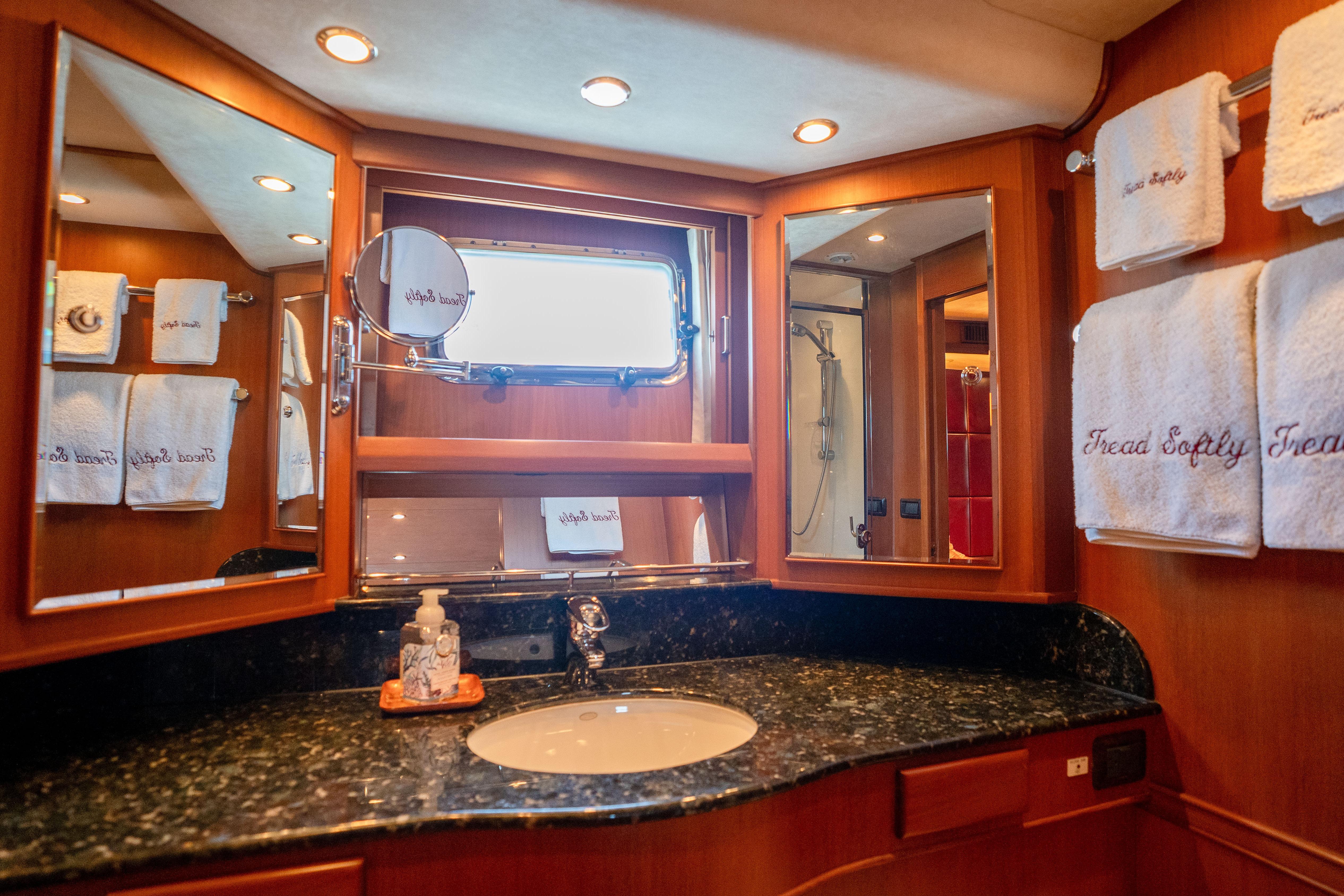 Luxurious bathroom in 2006 Fleming 75 yacht with elegant wood and marble finishes.