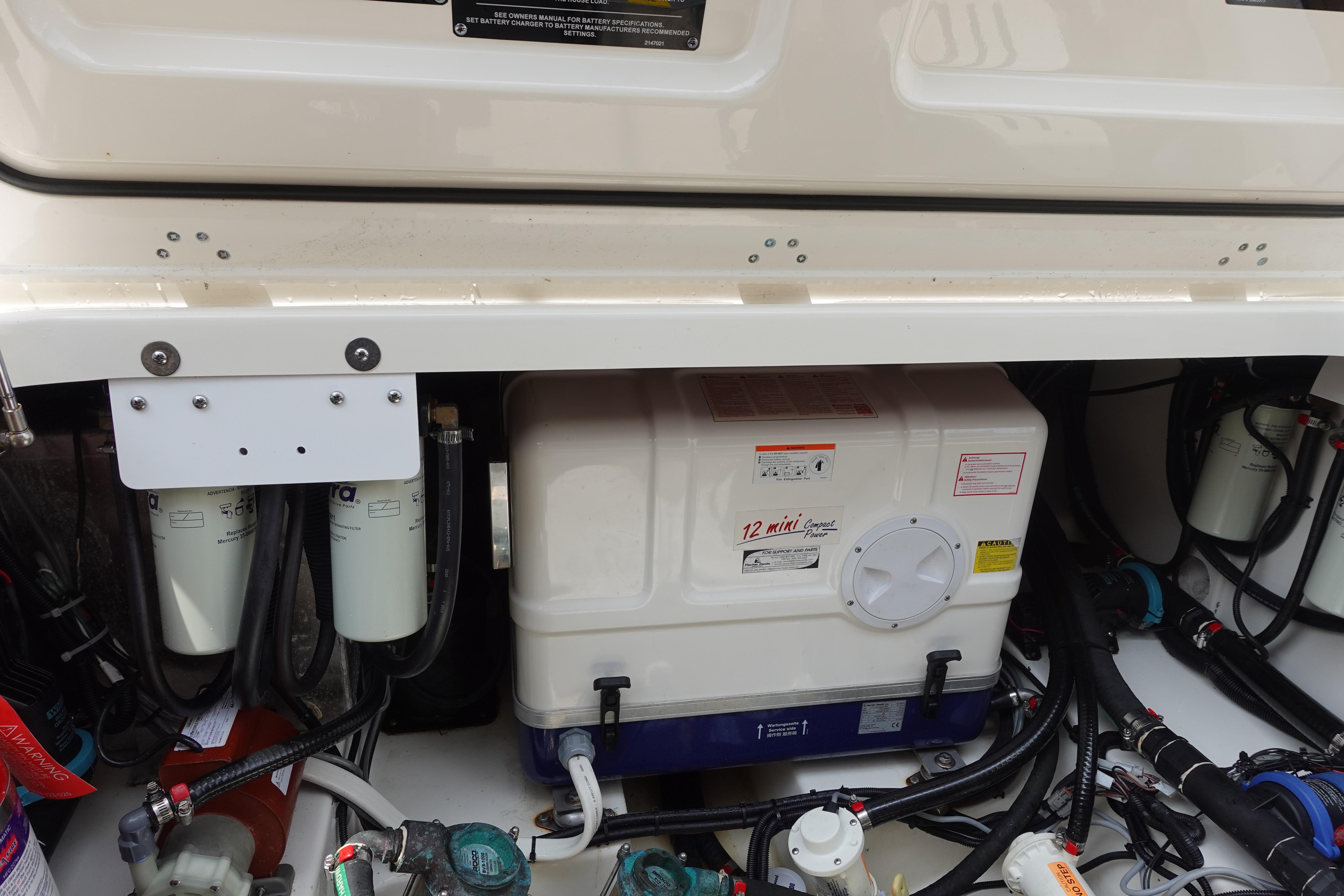 Engine compartment of a 2020 Boston Whaler 420 Outrage, showcasing filters and equipment.