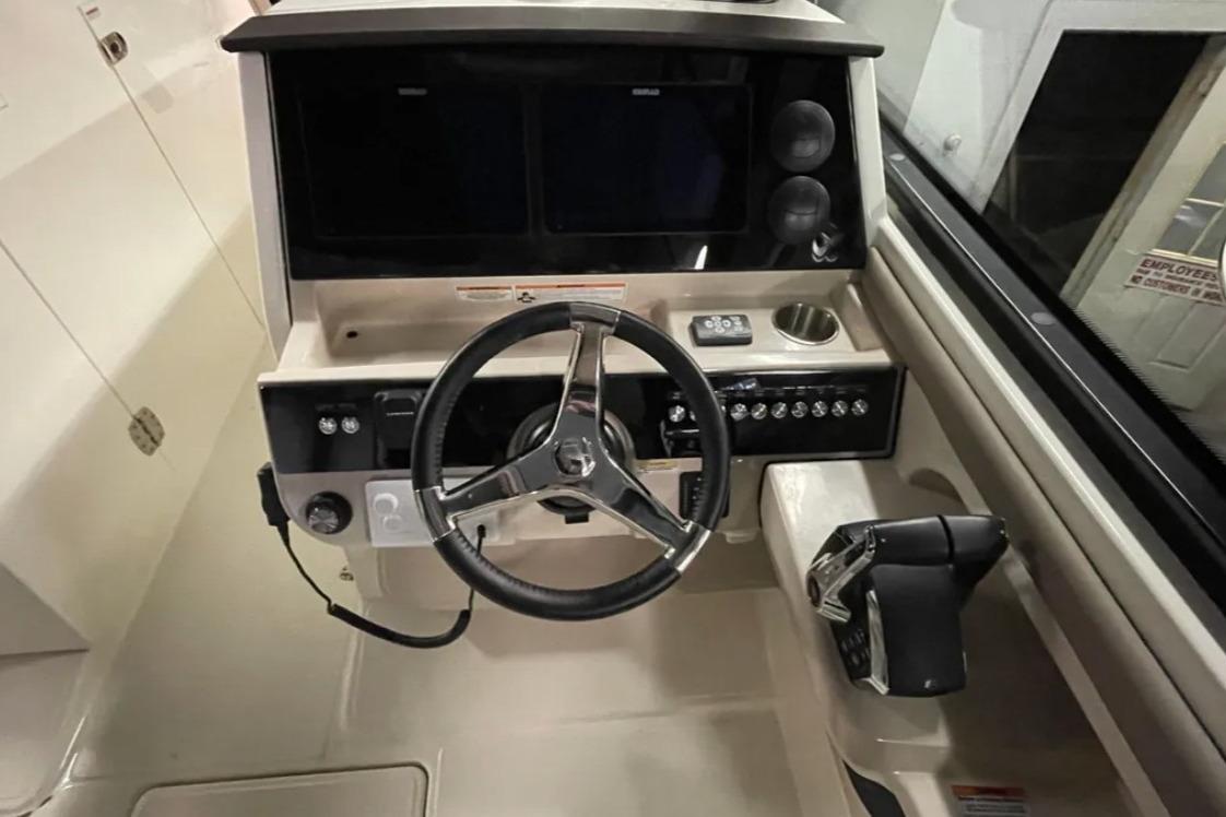 2025 Boston Whaler 330 Vantage helm with steering wheel and control panel.