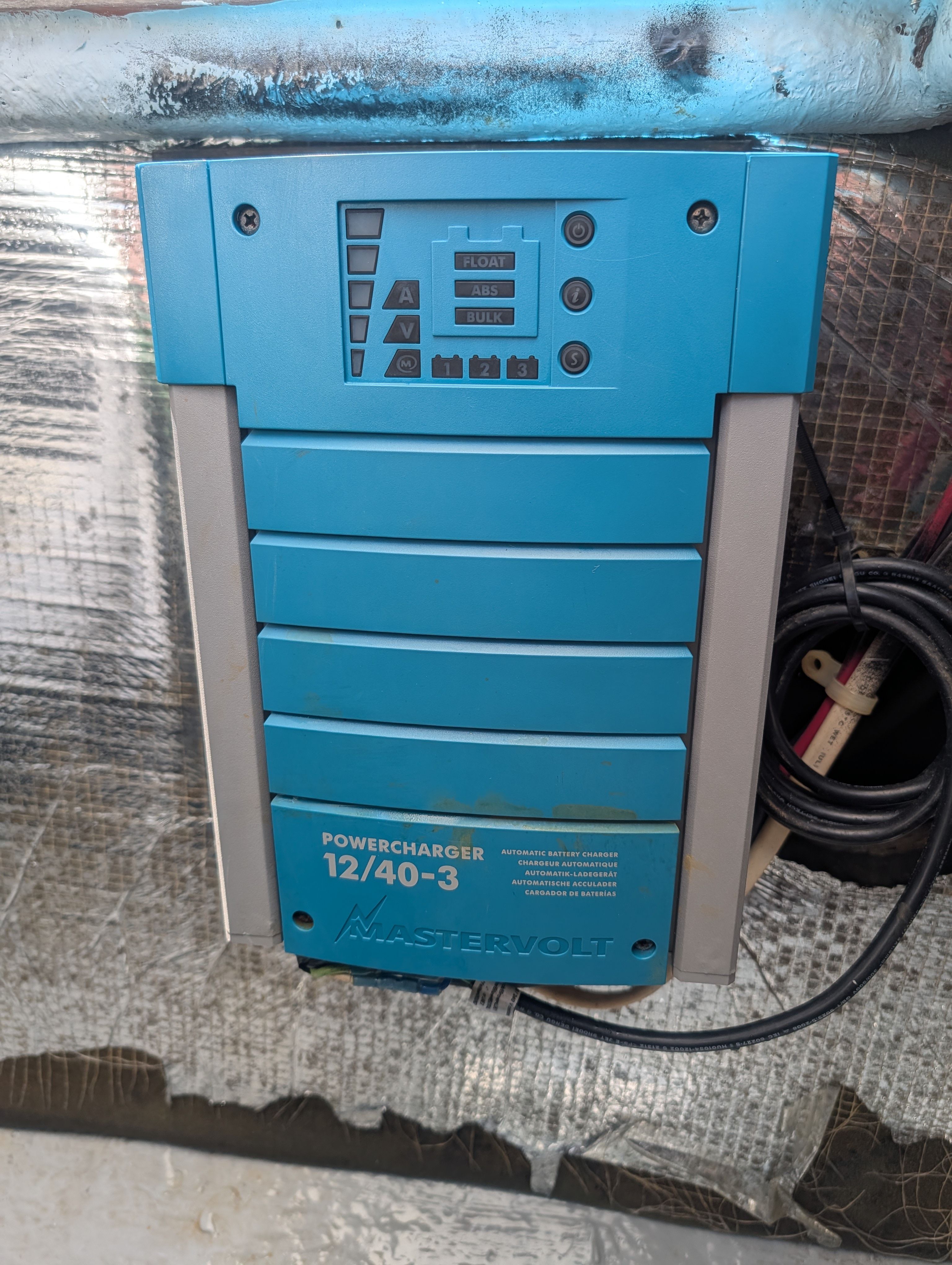 A blue charger is mounted on a wall.