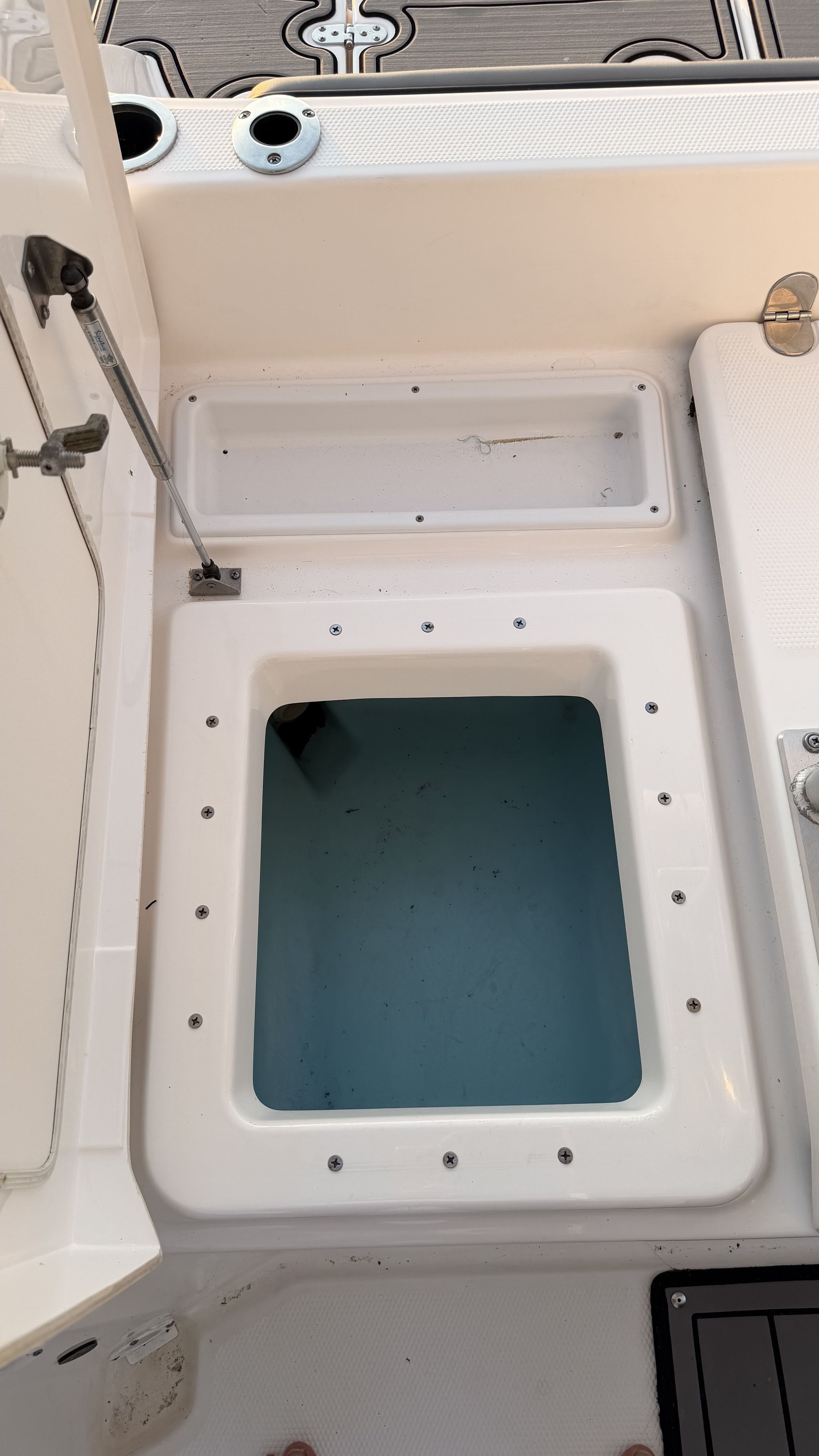 An open storage compartment on a 2019 Yamaha 190 FSH Sport boat.