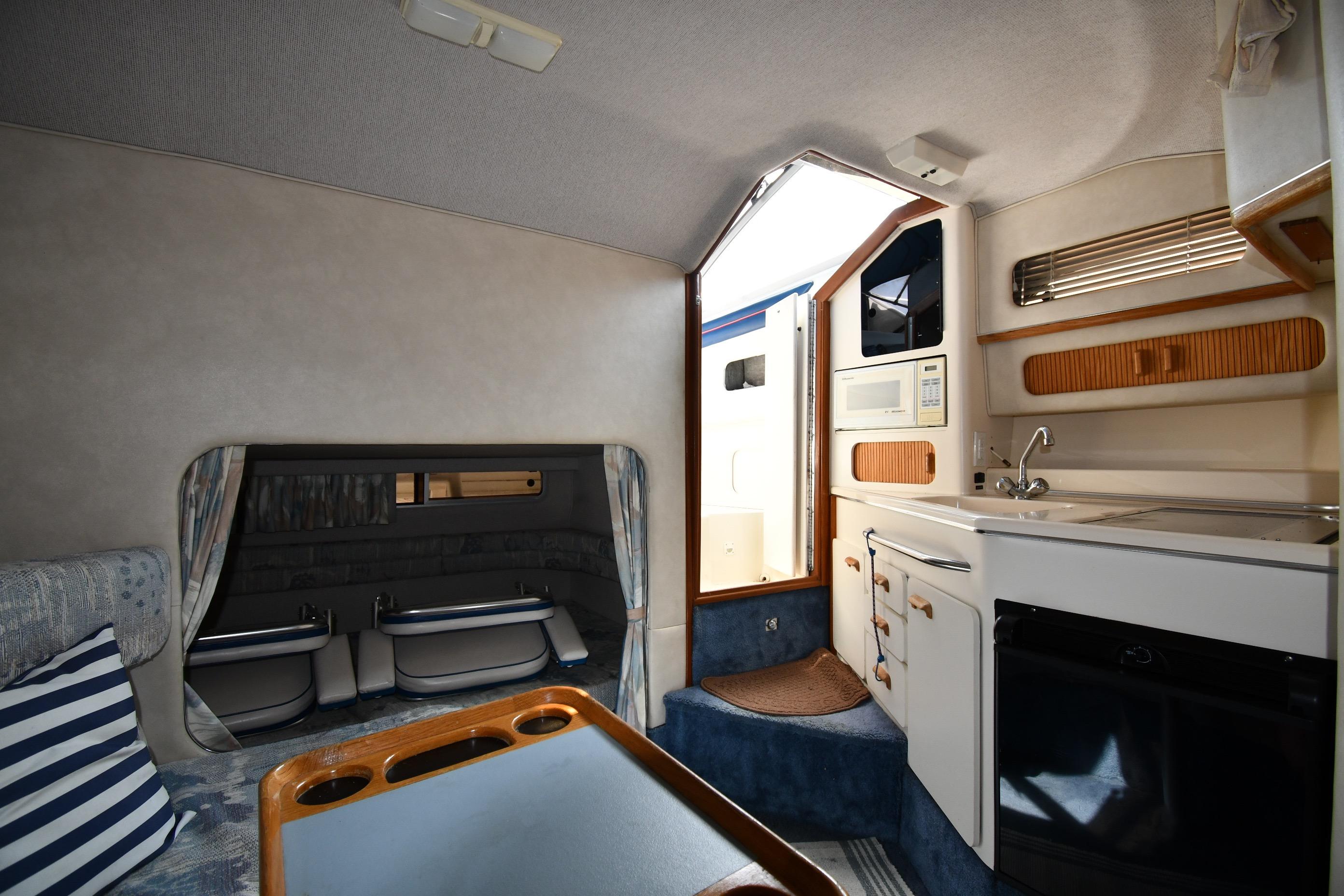 Interior of a 1993 Sea Ray 300 Sundancer boat, featuring a kitchenette and seating area.
