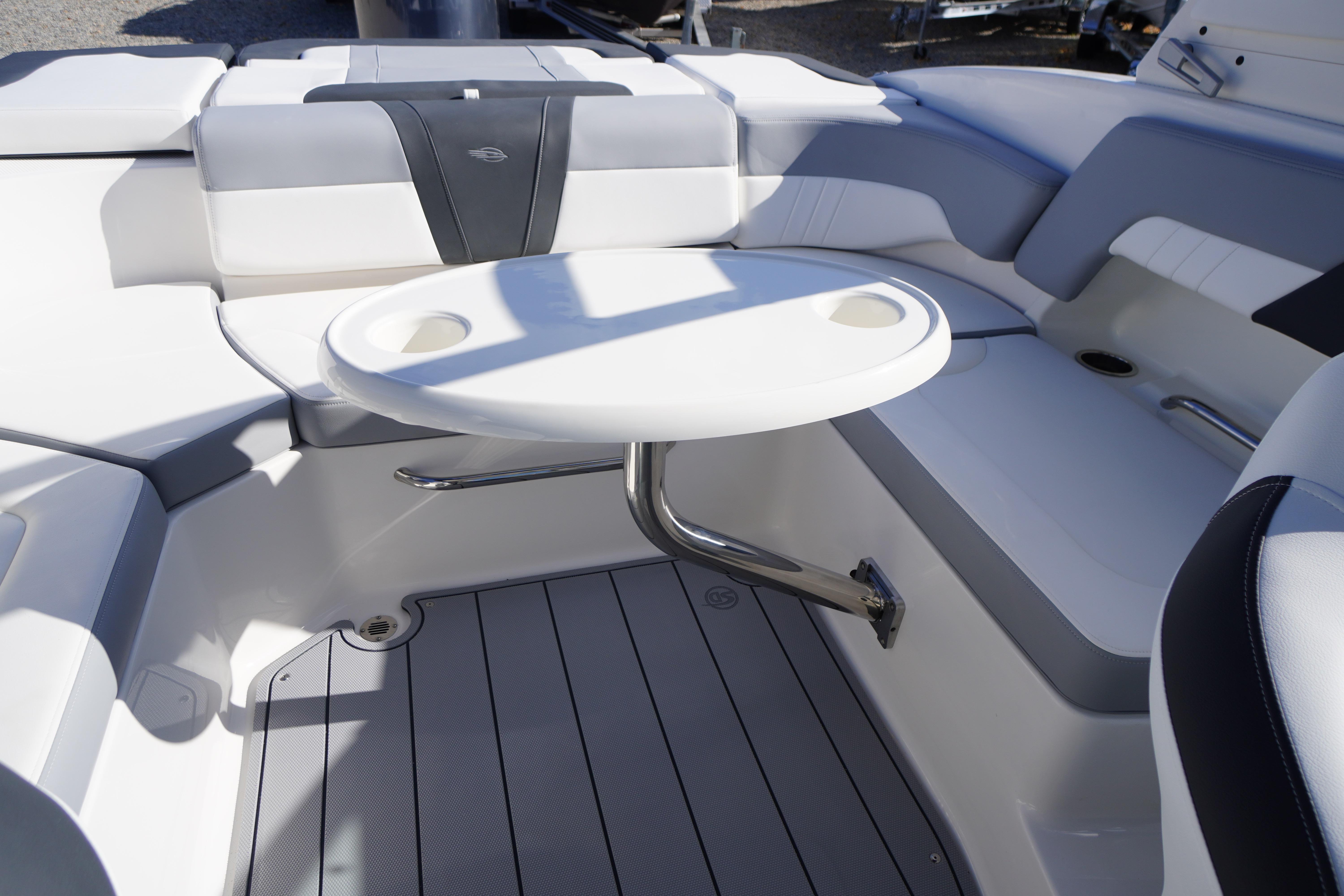 2026 Chaparral 23 SSi OB boat interior with seating and round table.