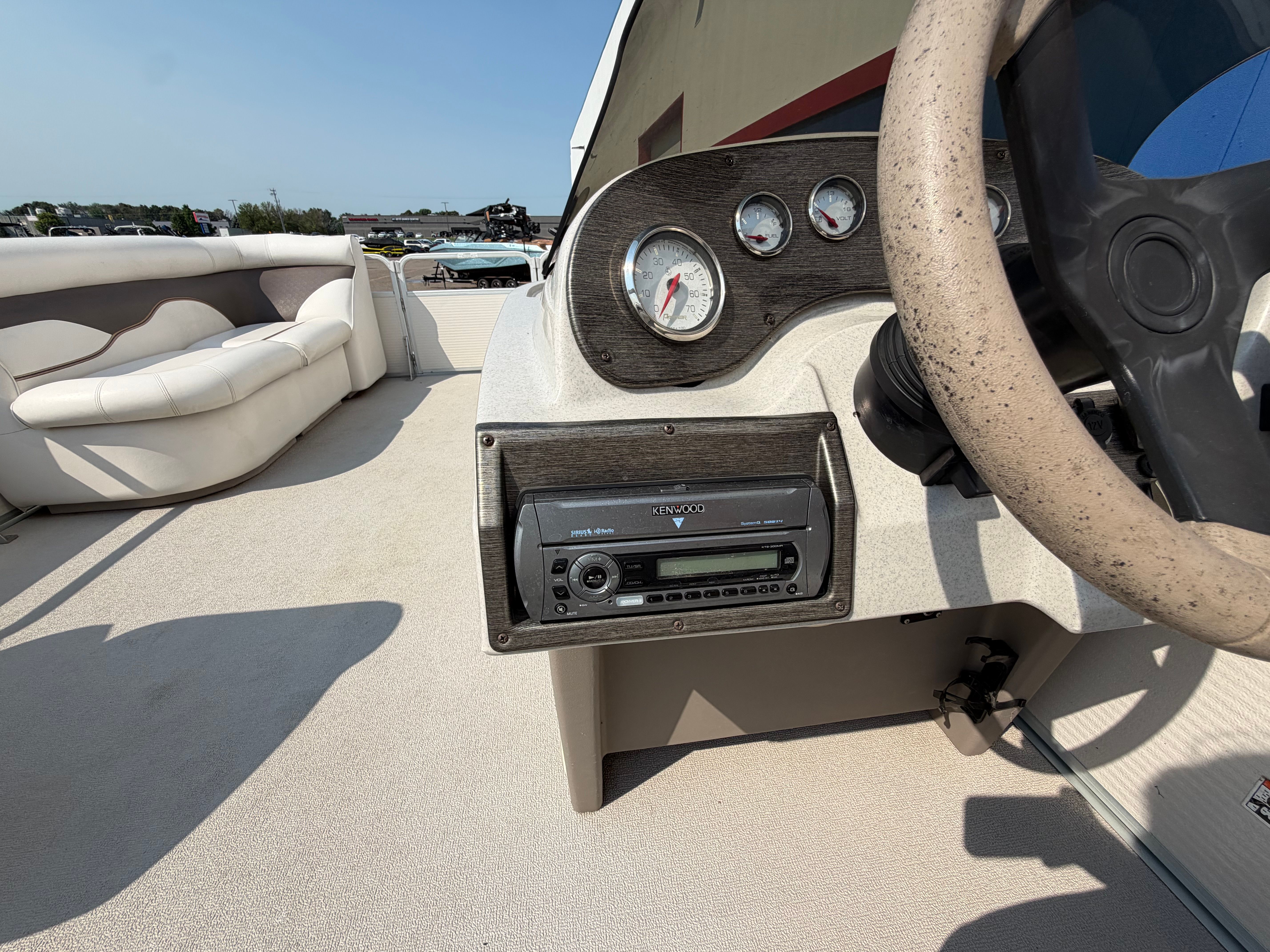 The image shows the cockpit of a 2007 Premier 225 Sunsation pontoon boat with a steering wheel and radio.