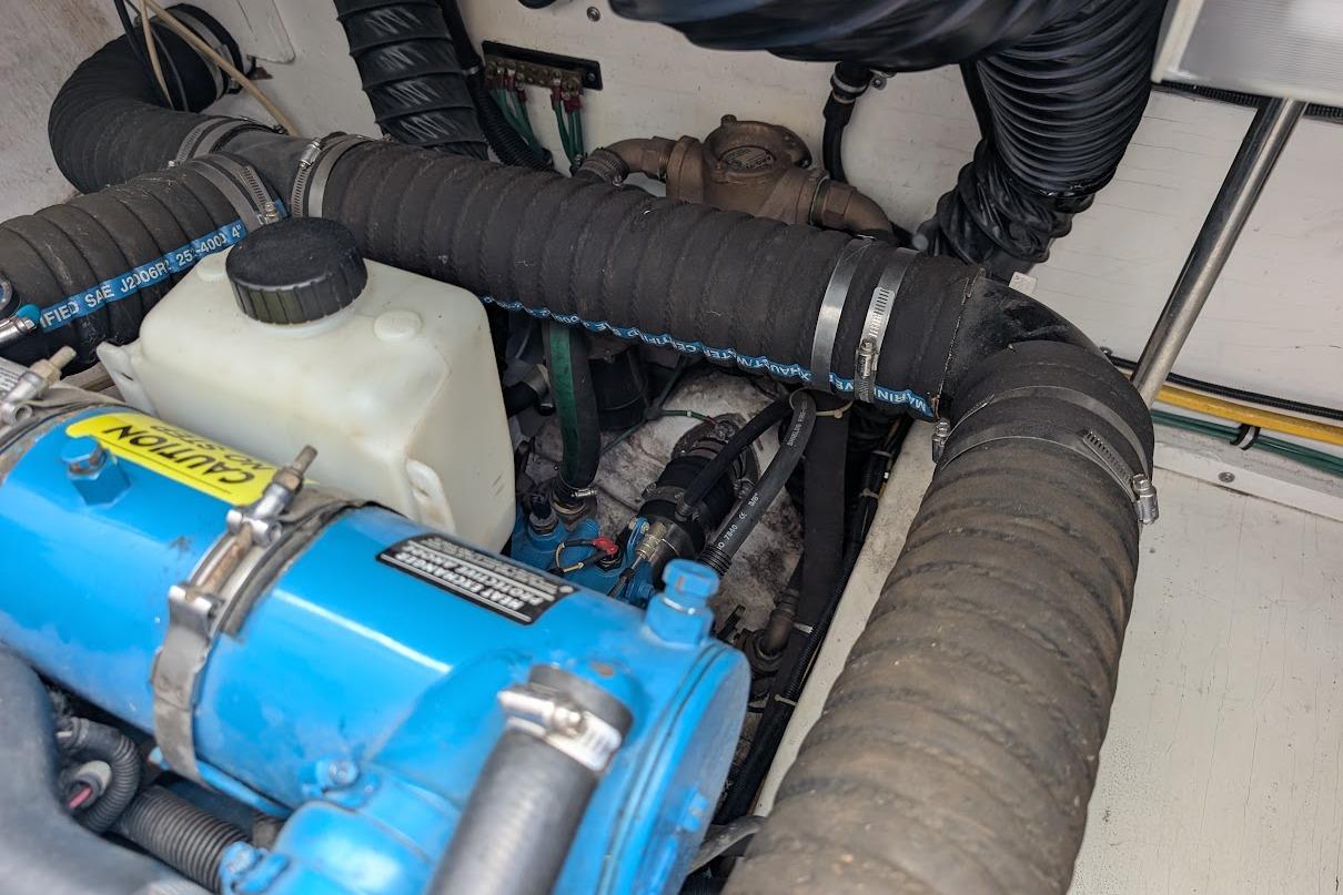Engine compartment of a 2000 Pursuit 3400 Express boat, featuring hoses and components.
