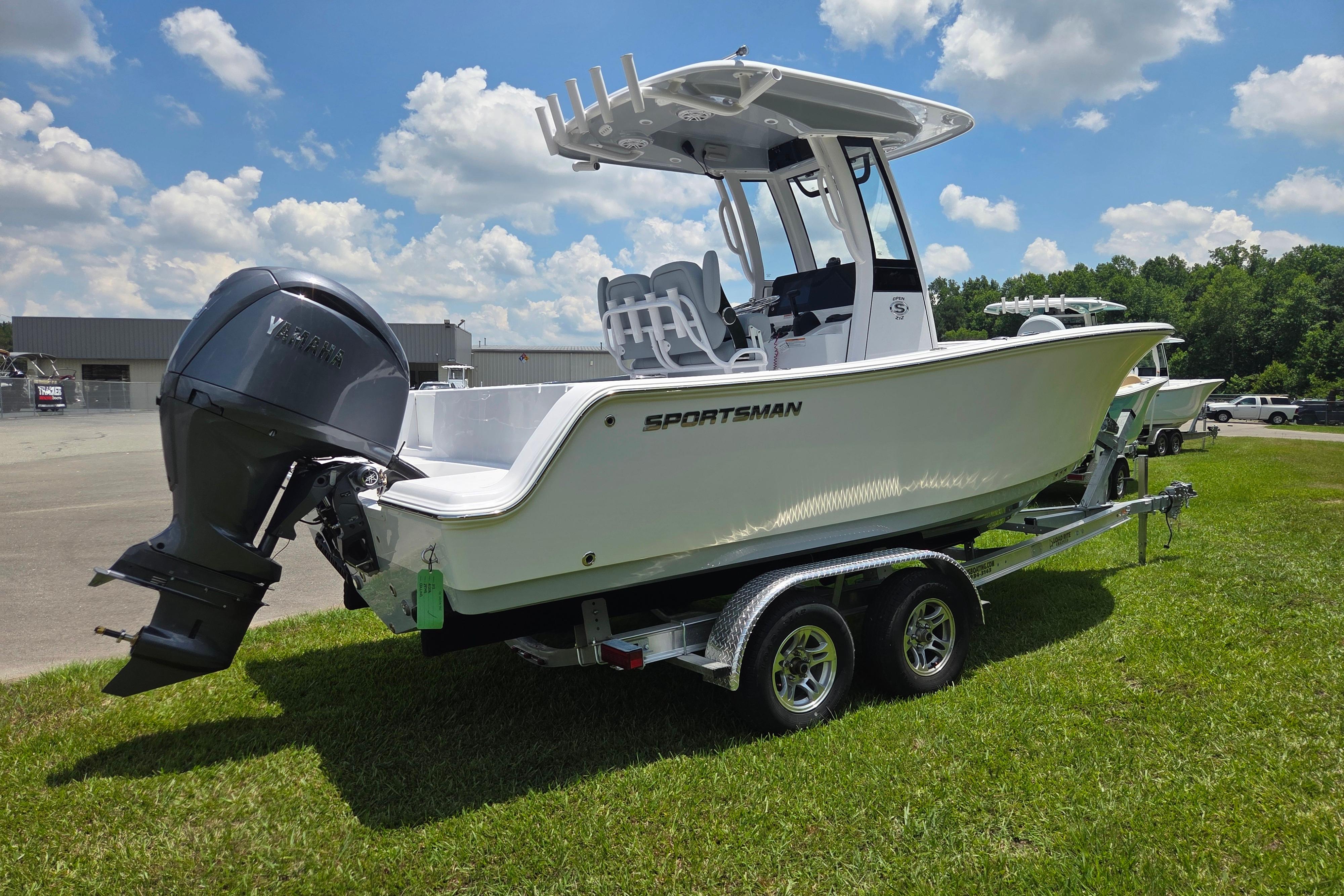 2026 Sportsman Open 212 Center Console boat on trailer, parked on grass under blue sky.