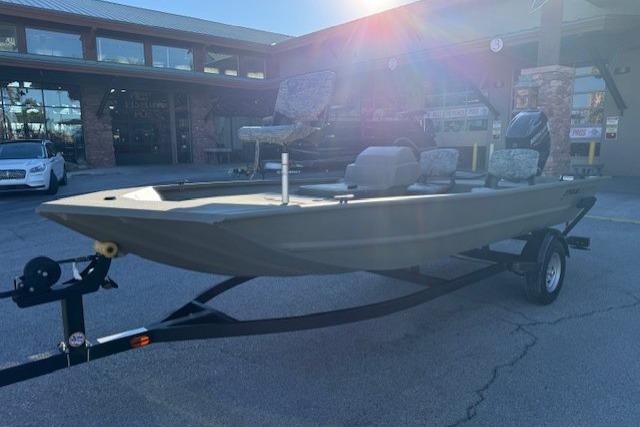 2026 Tracker Grizzly 1754 SC boat on trailer, parked outdoors in sunlight.