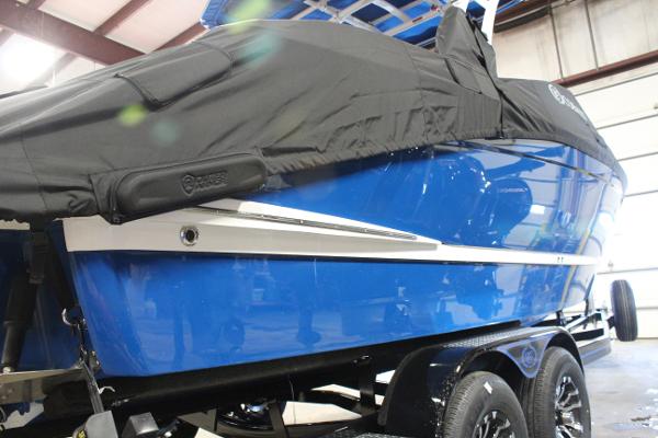 2025 Cobalt R6 boat in blue with a black cover, on a trailer indoors.