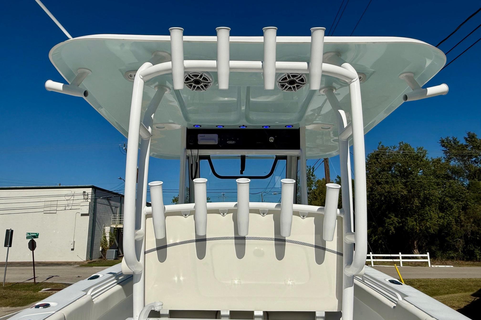 2026 Sea Hunt Gamefish 30 Coffin Box boat with rod holders and speakers, under clear blue sky.