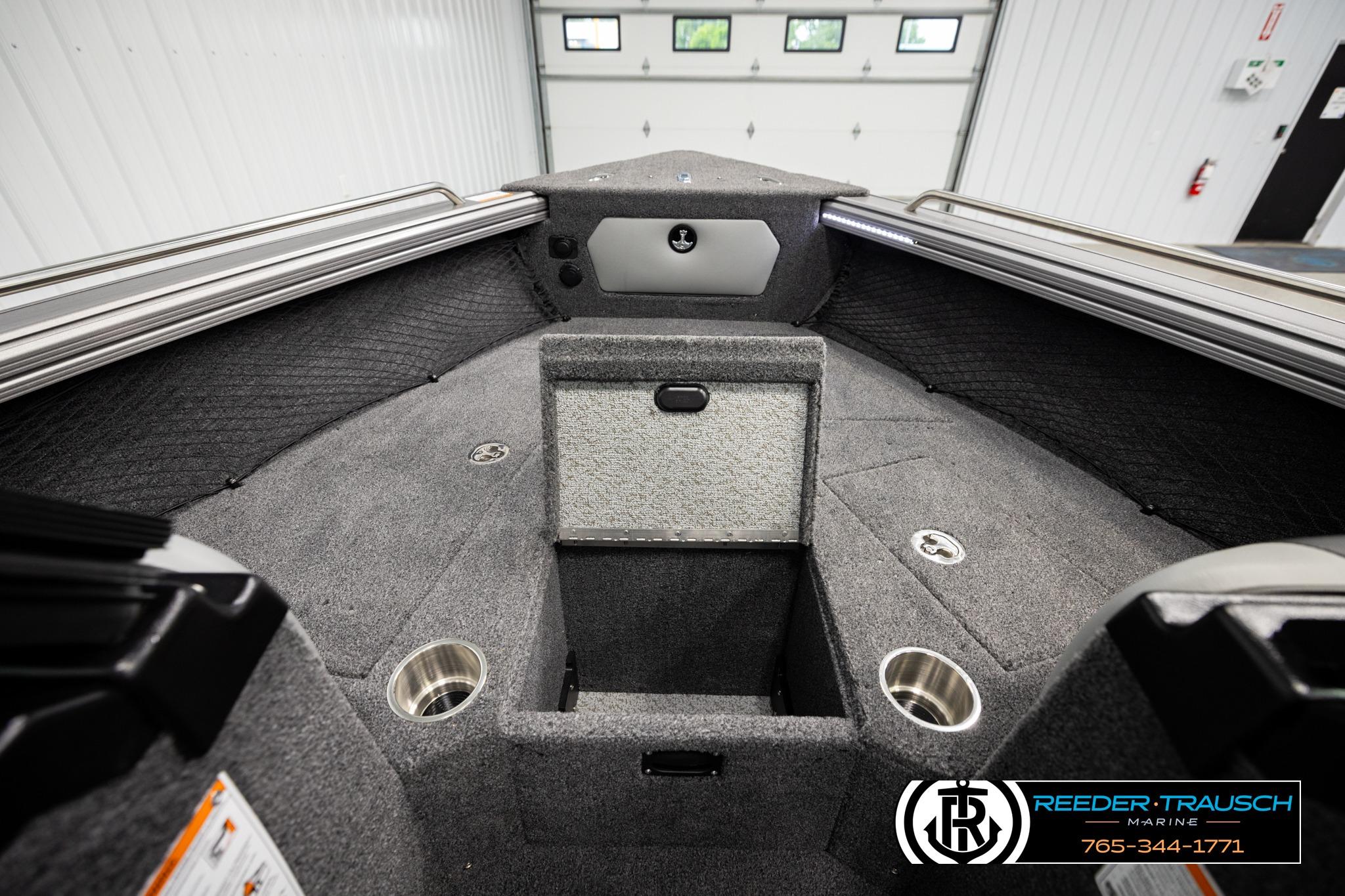 Interior of 2026 Lund 1975 Tyee boat with storage compartments and cup holders.