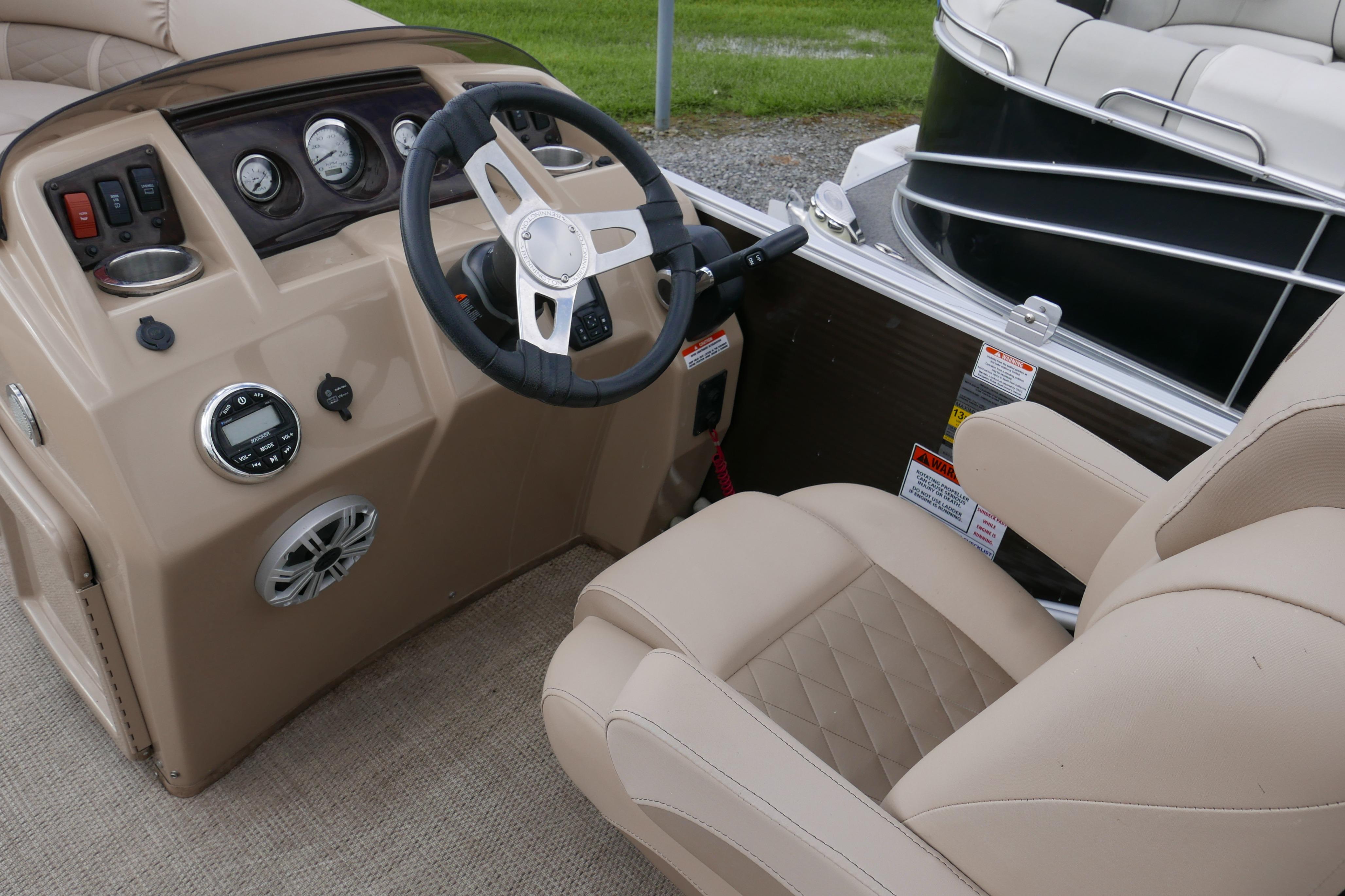 2018 Bennington 22 SSRX boat interior with steering wheel and beige seating.