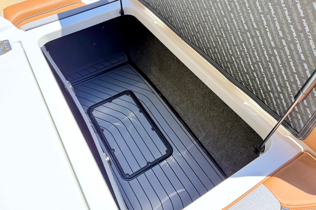 2021 Nautique Super Air Nautique G23 storage compartment with open lid, showcasing interior space.