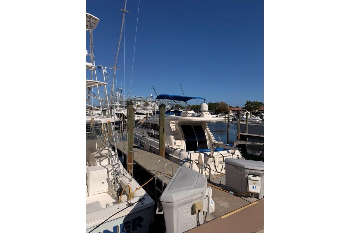 1999 Sealine F44 yacht docked at a marina under clear blue skies.