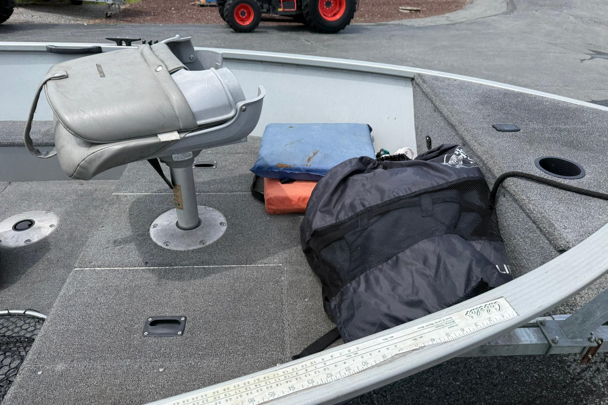 2013 Alumacraft Fisherman 160 Tiller boat interior with seat, gear, and storage compartments.