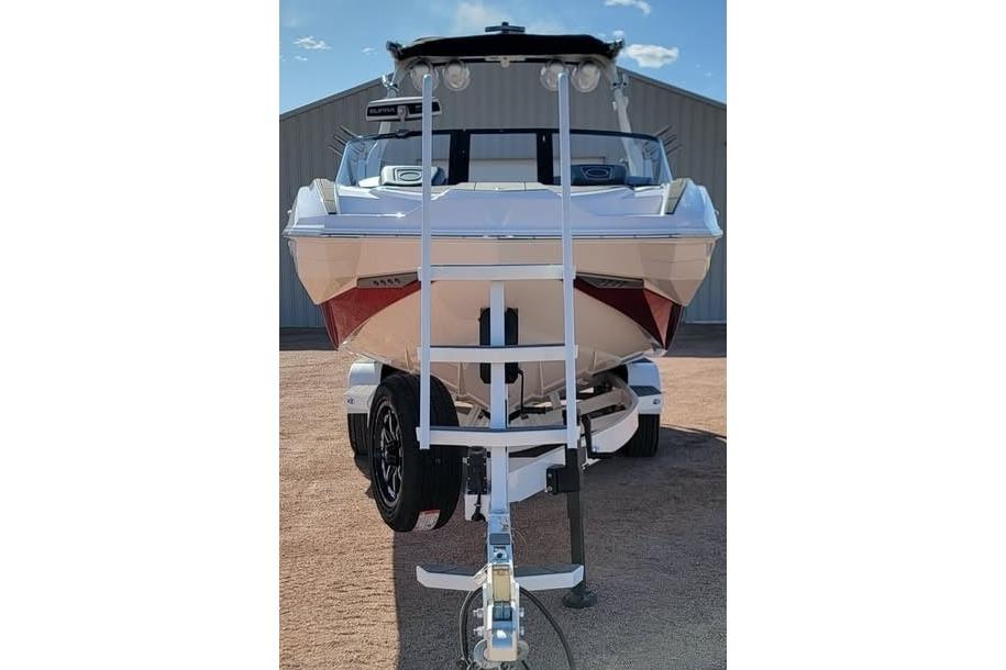 2023 Supra SE 550 boat on trailer, front view, parked outdoors.