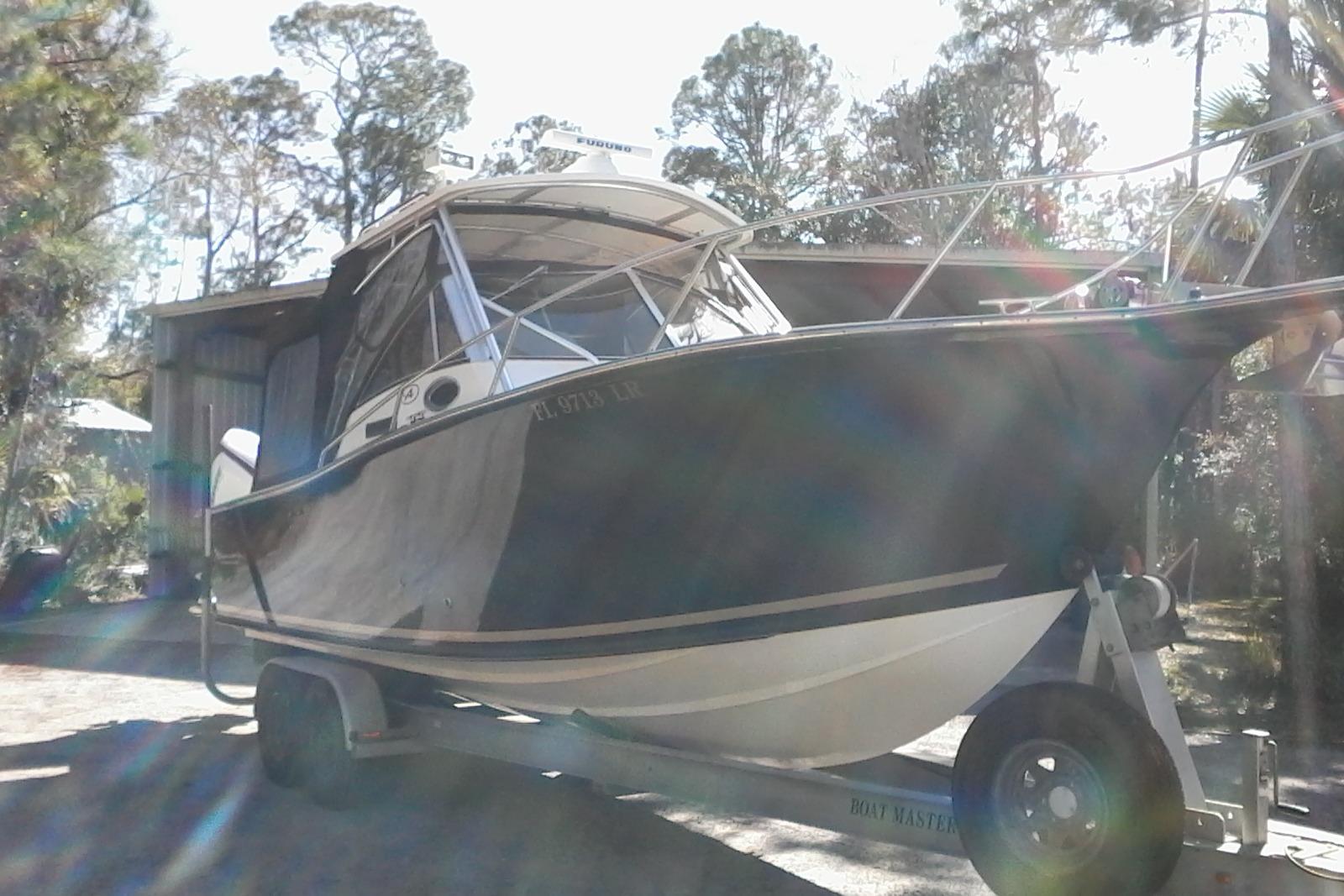 2002 Albemarle 265 Express Fisherman boat on trailer, surrounded by trees.