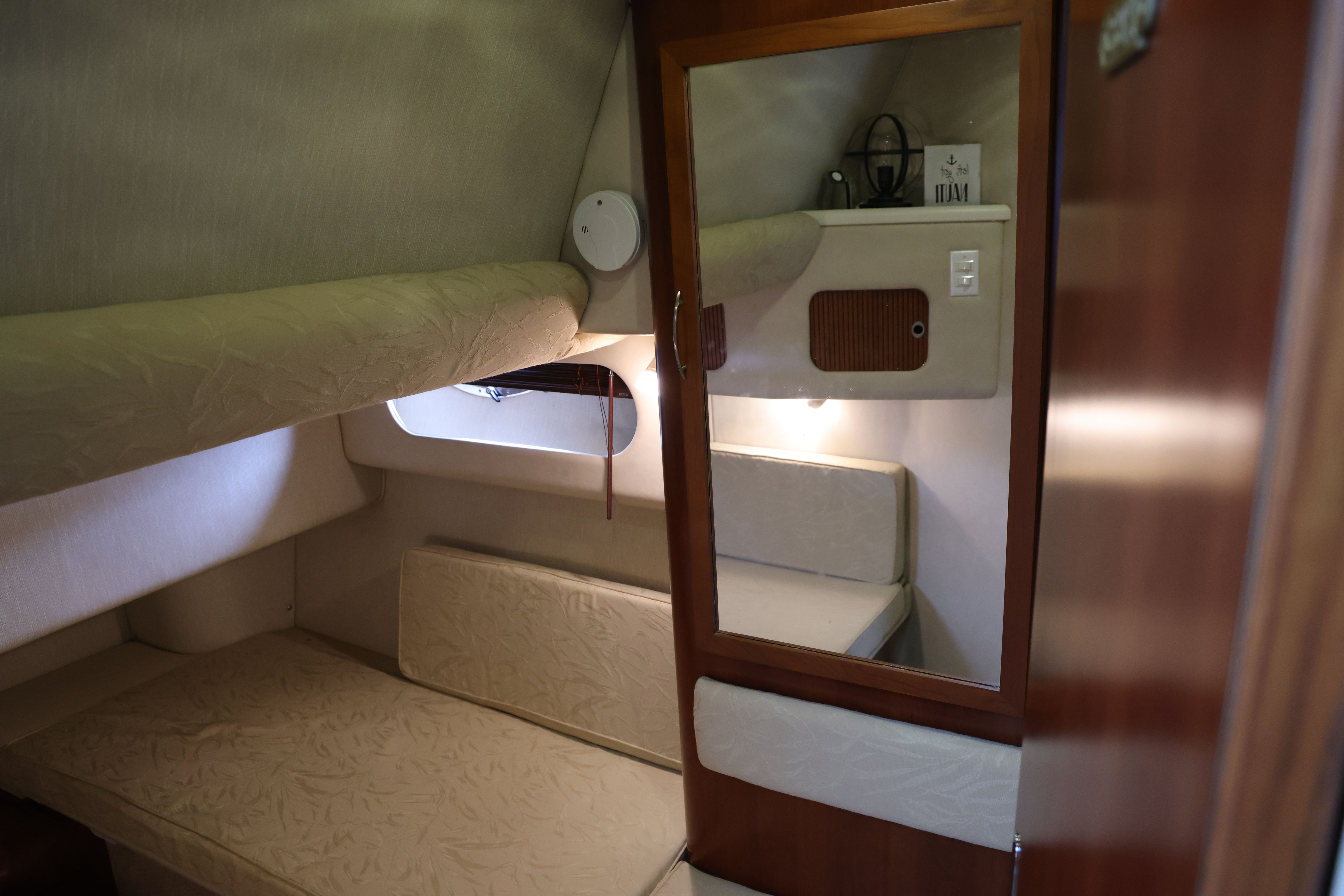 Interior of a 1996 Sea Ray 400 Sedan Bridge with sleeping area and mirror.