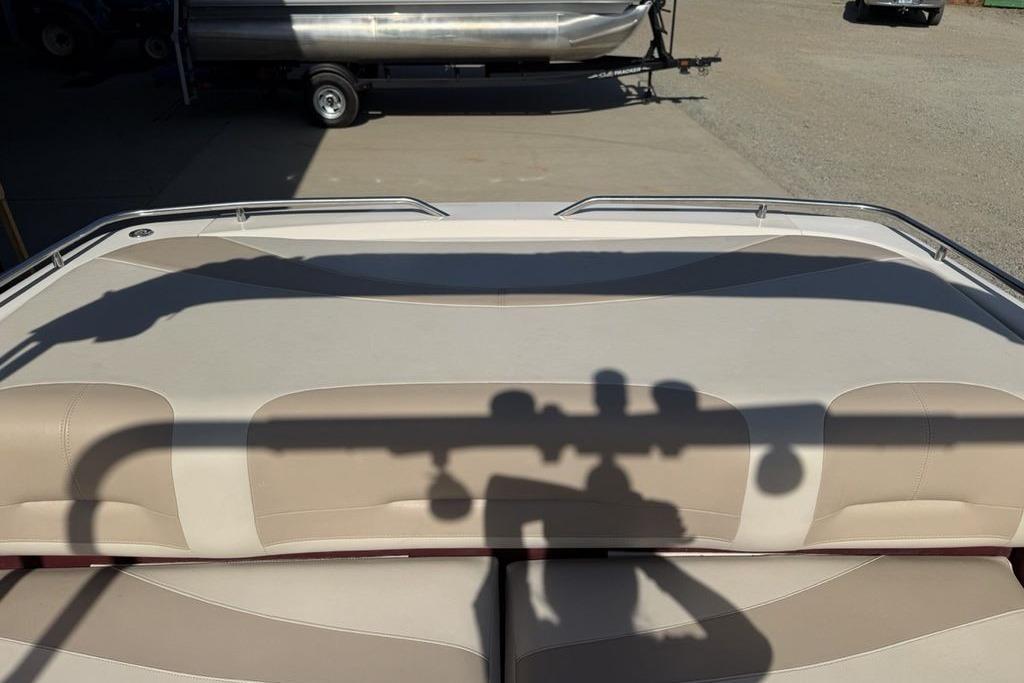 1999 Glastron GT 225 boat interior with beige seating and shadow on upholstery.