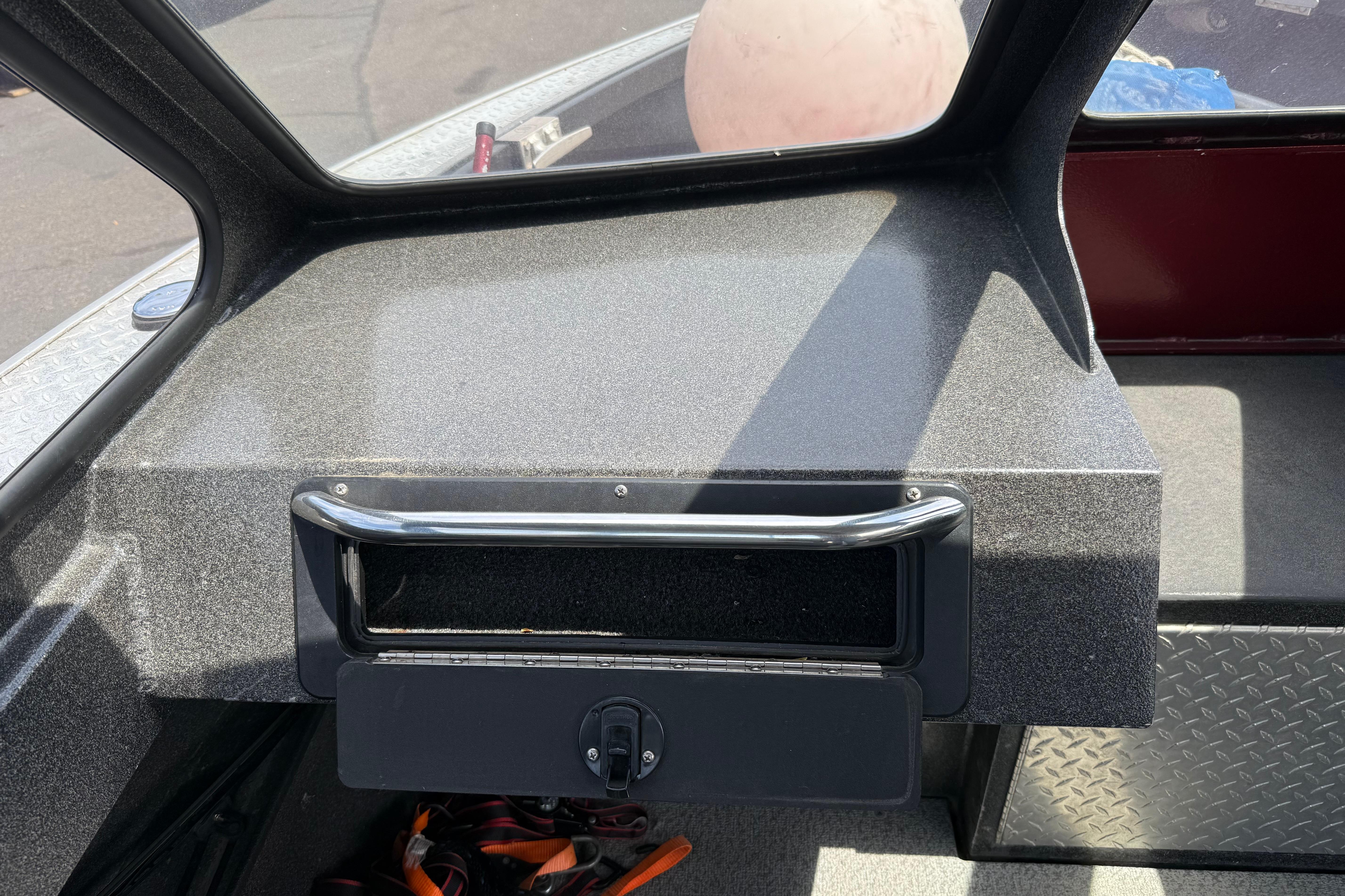 Dashboard of a 2005 Willie Raptor 21' boat with storage compartment.
