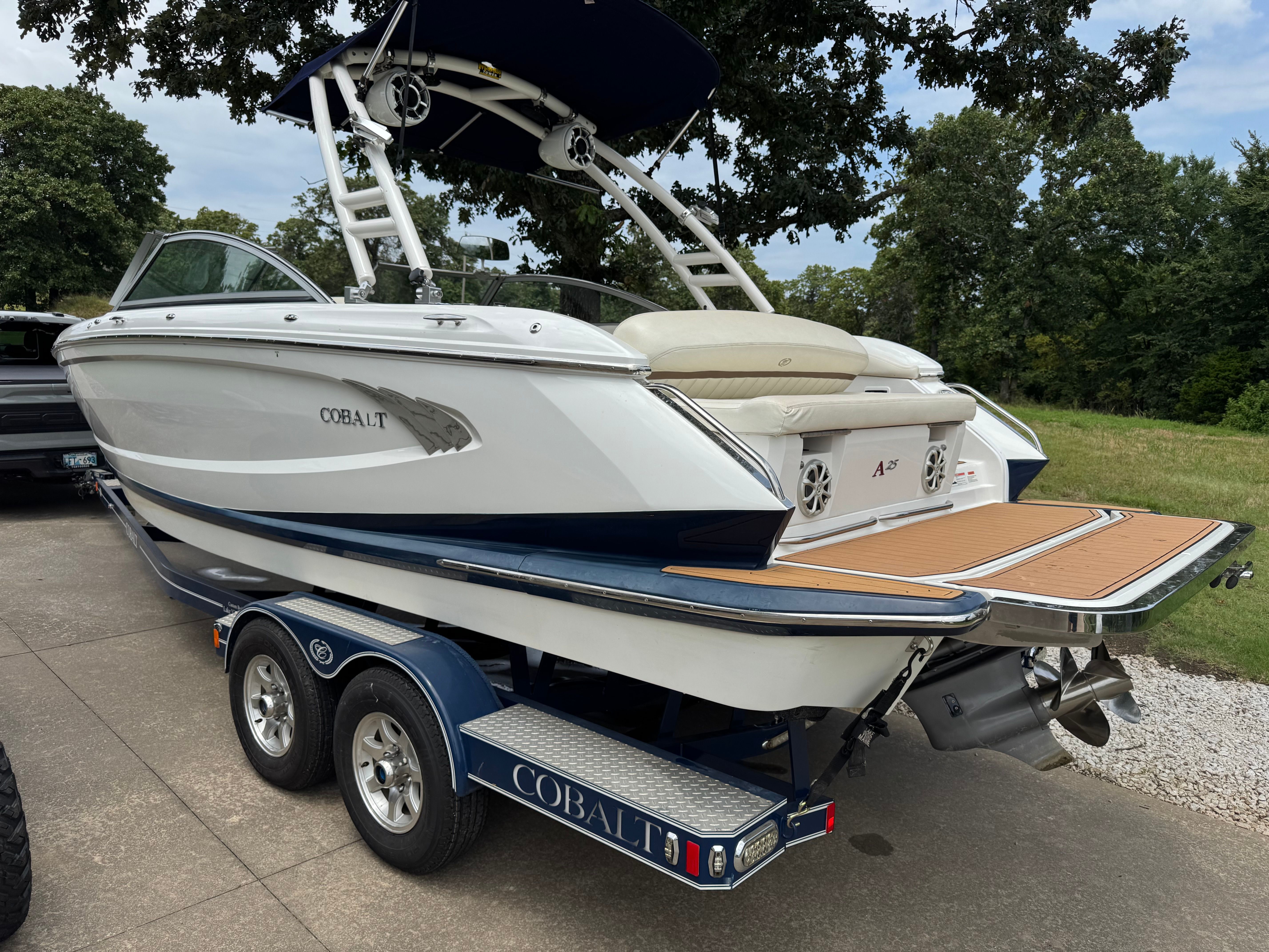 A 2011 Cobalt A25 boat on a trailer. It features a sleek design and a swim platform.