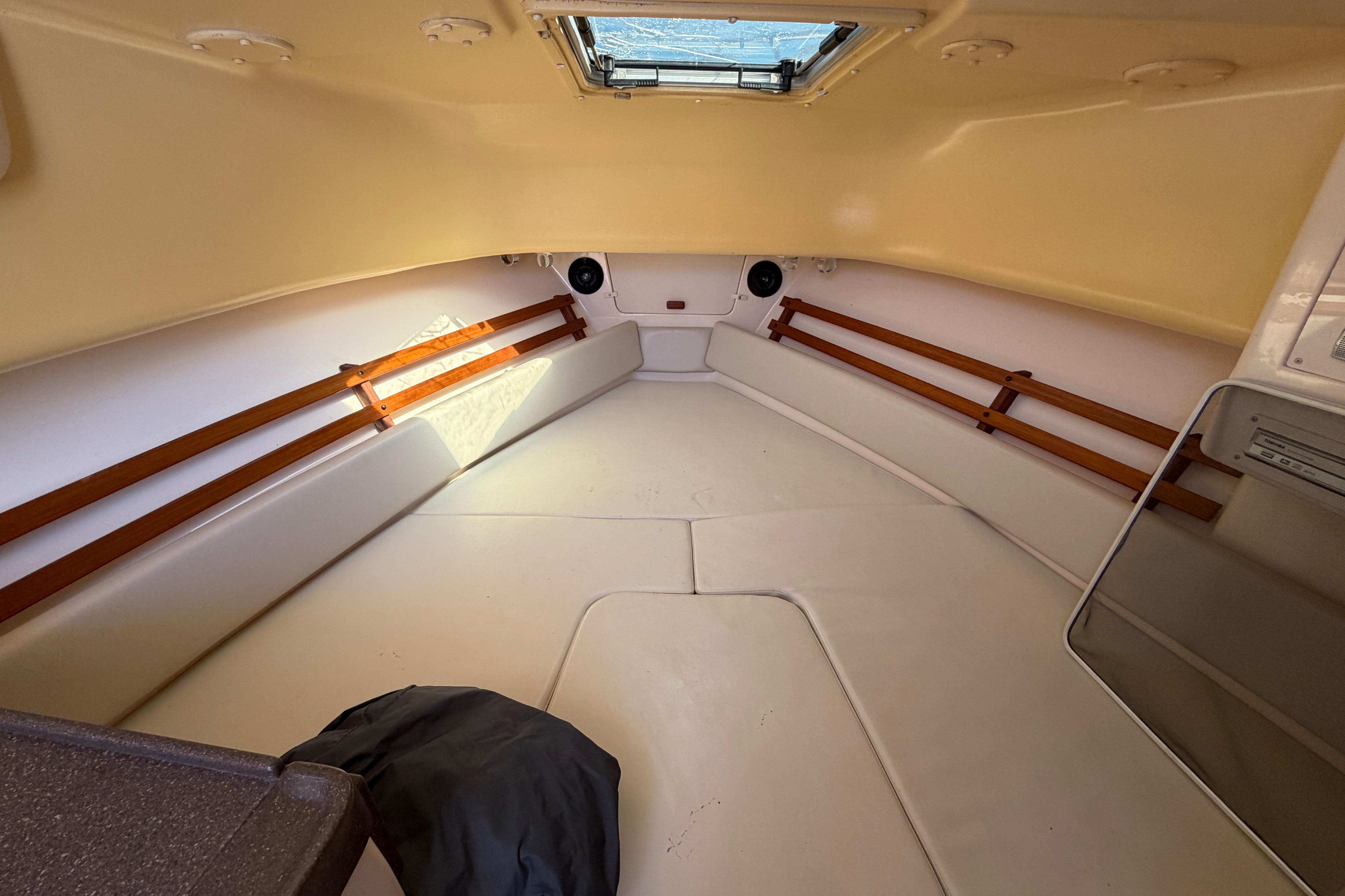 2006 Grady-White Sailfish 282 cabin interior with beige upholstery and wooden accents.