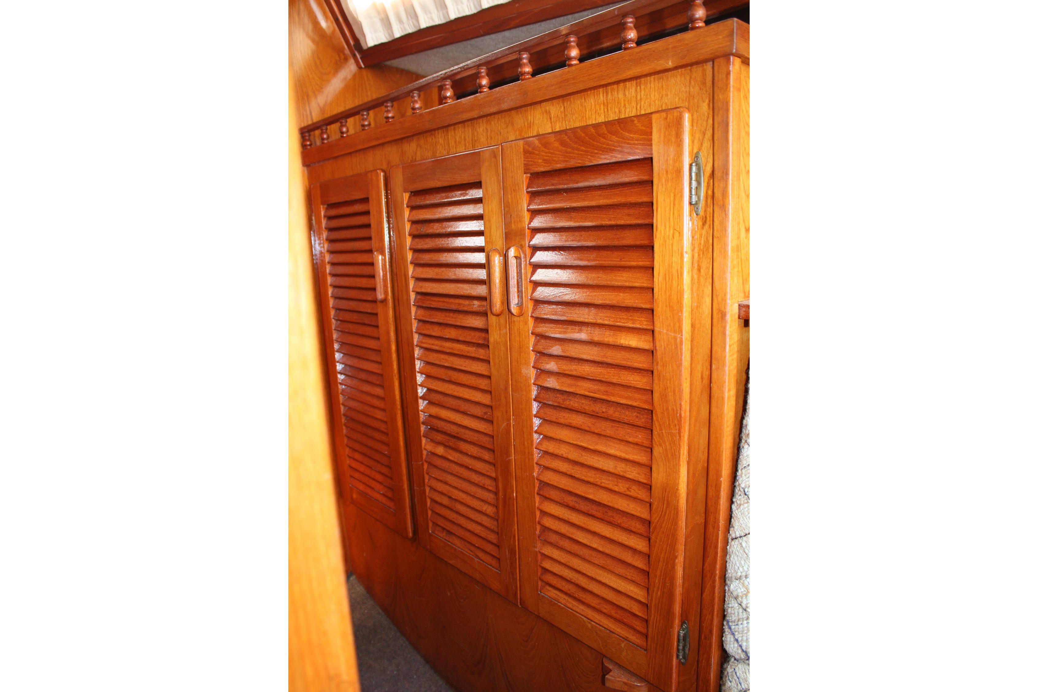 Wooden louvered cabinet doors inside a 1981 S2 9.2A sailboat interior.