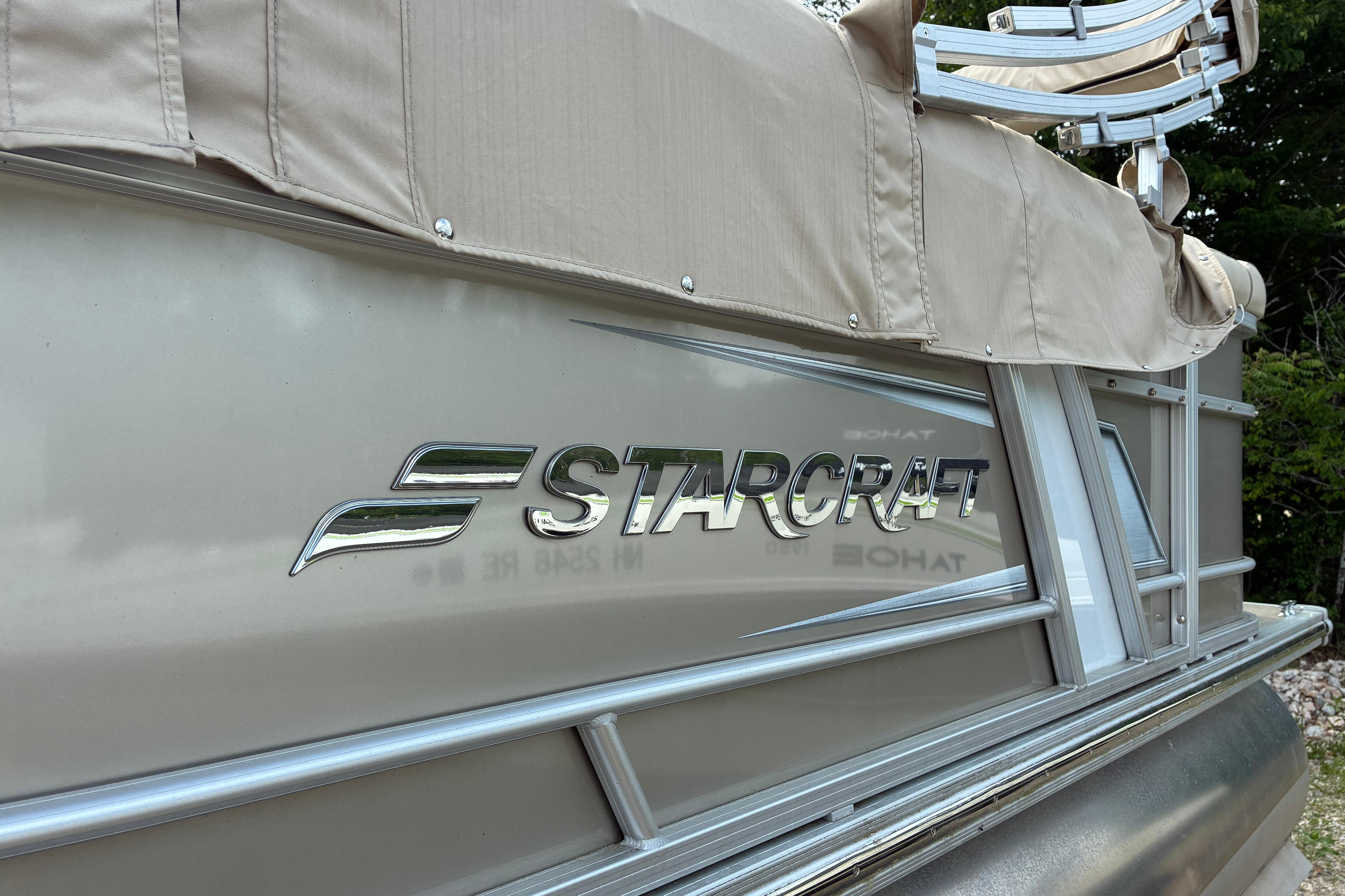 2020 Starcraft EX 20 C boat with beige canopy and metallic logo.