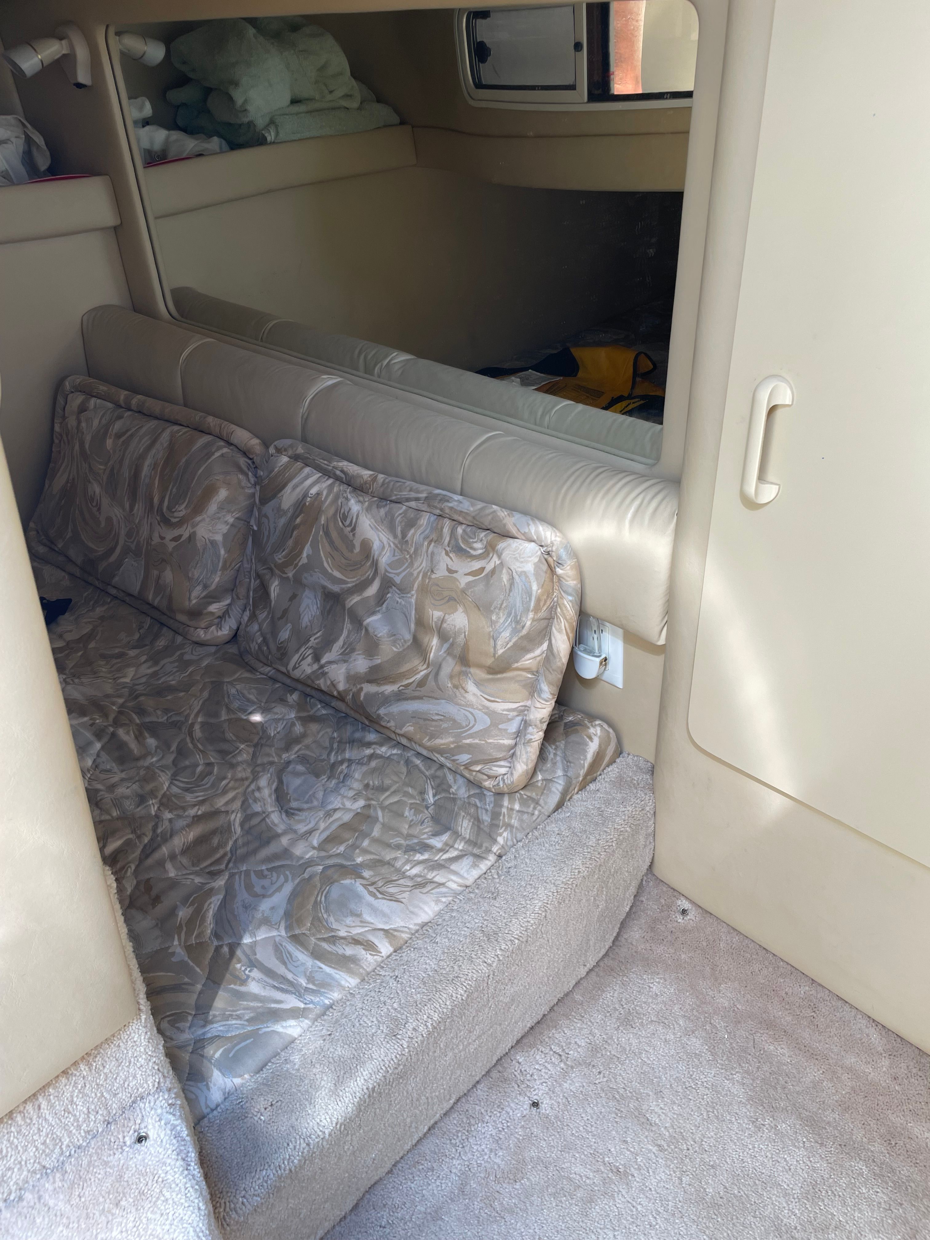 Interior of a 1998 Sea Ray 270 Sundancer with cushioned seating and storage space.