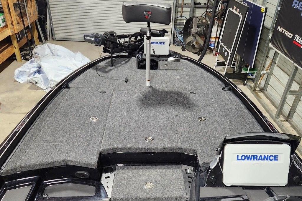 2026 Triton 20XP Patriot boat deck with Lowrance electronics in a garage setting.