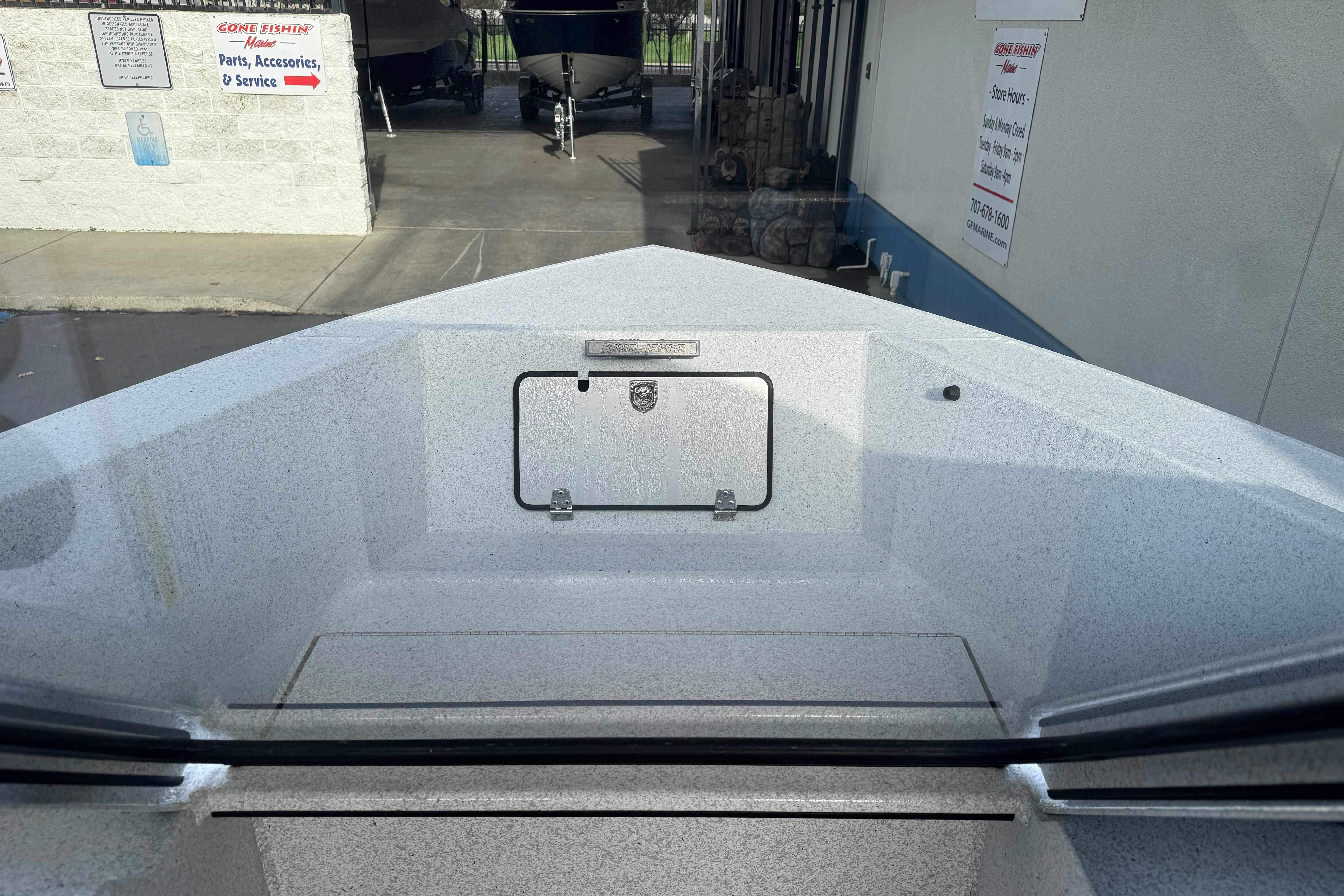 Bow view of 2026 KingFisher 2025 Escape boat at dealership service area.
