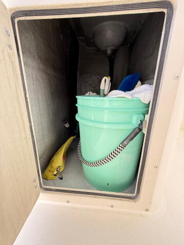 Storage compartment on a 2001 Albemarle 280 Express Sport Fisherman with cleaning supplies.