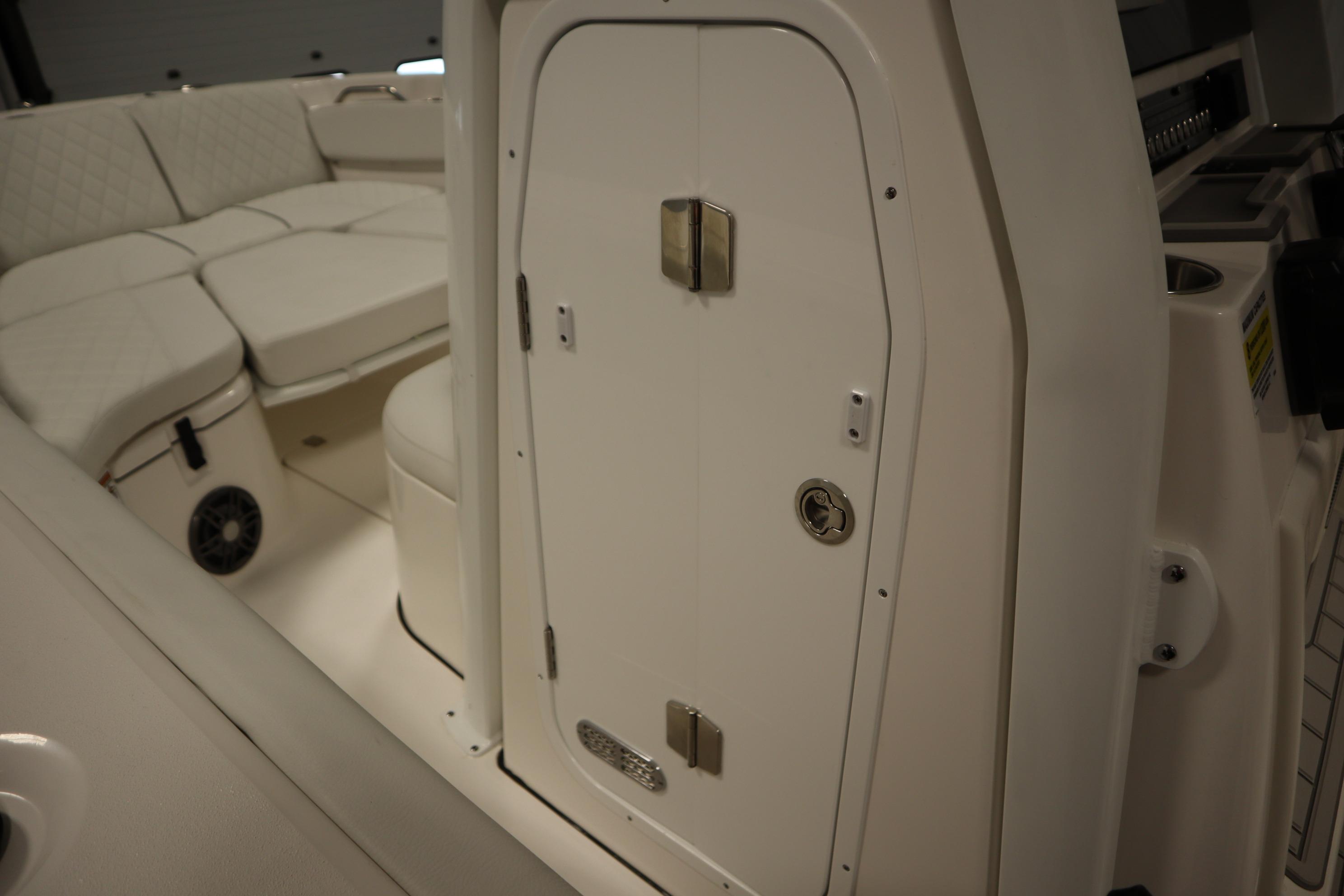 2026 Sea Fox 228 Commander interior with cushioned seating and storage compartment.