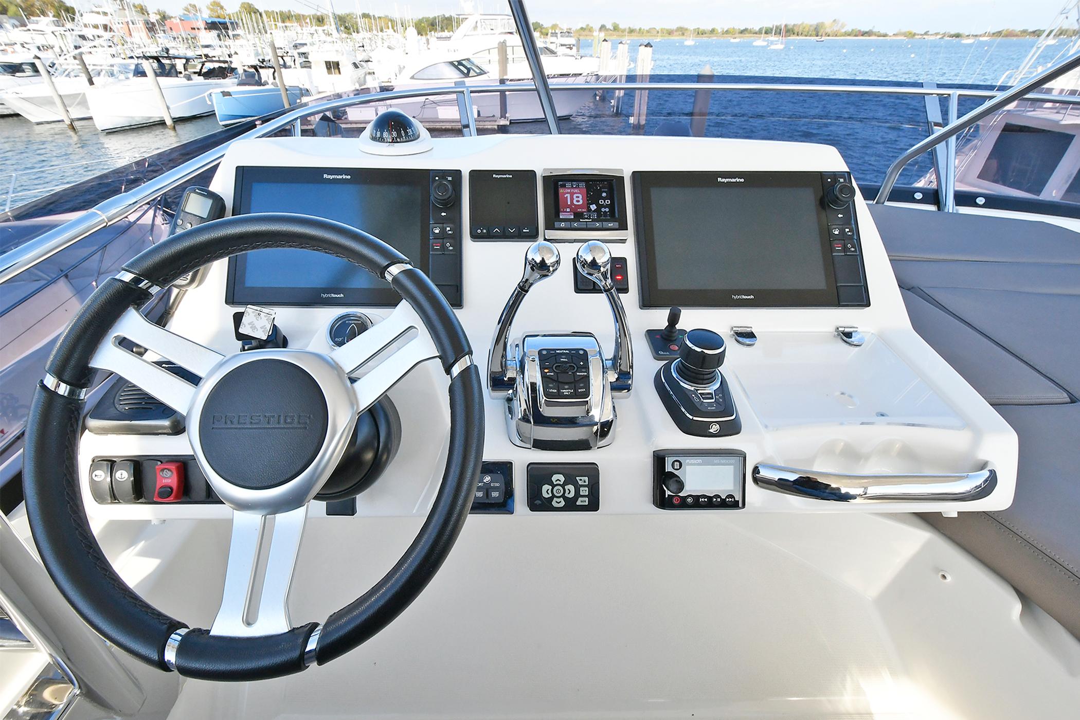 Helm of 2018 Prestige 560 Fly yacht with modern navigation equipment and steering wheel.