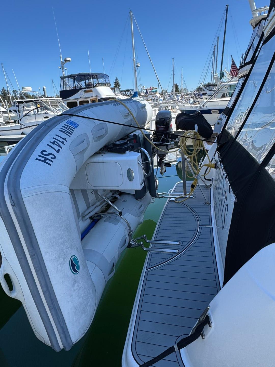 2003 Meridian 381 Sedan yacht with inflatable boat docked at marina.