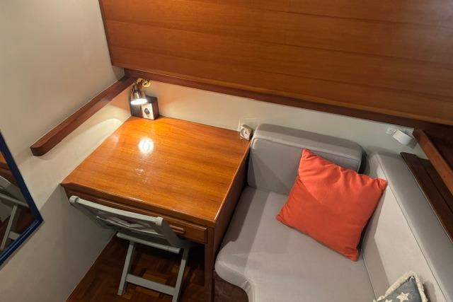Cozy interior of 1986 Kadey-Krogen 42 with wooden desk and cushioned seating.