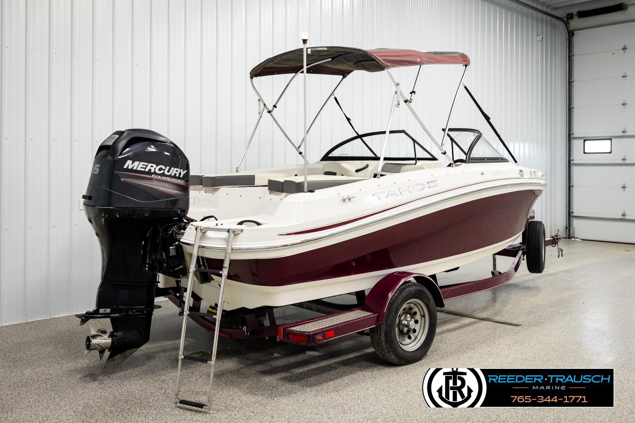 2016 Tahoe 450 TS boat with Mercury outboard motor in a garage setting.