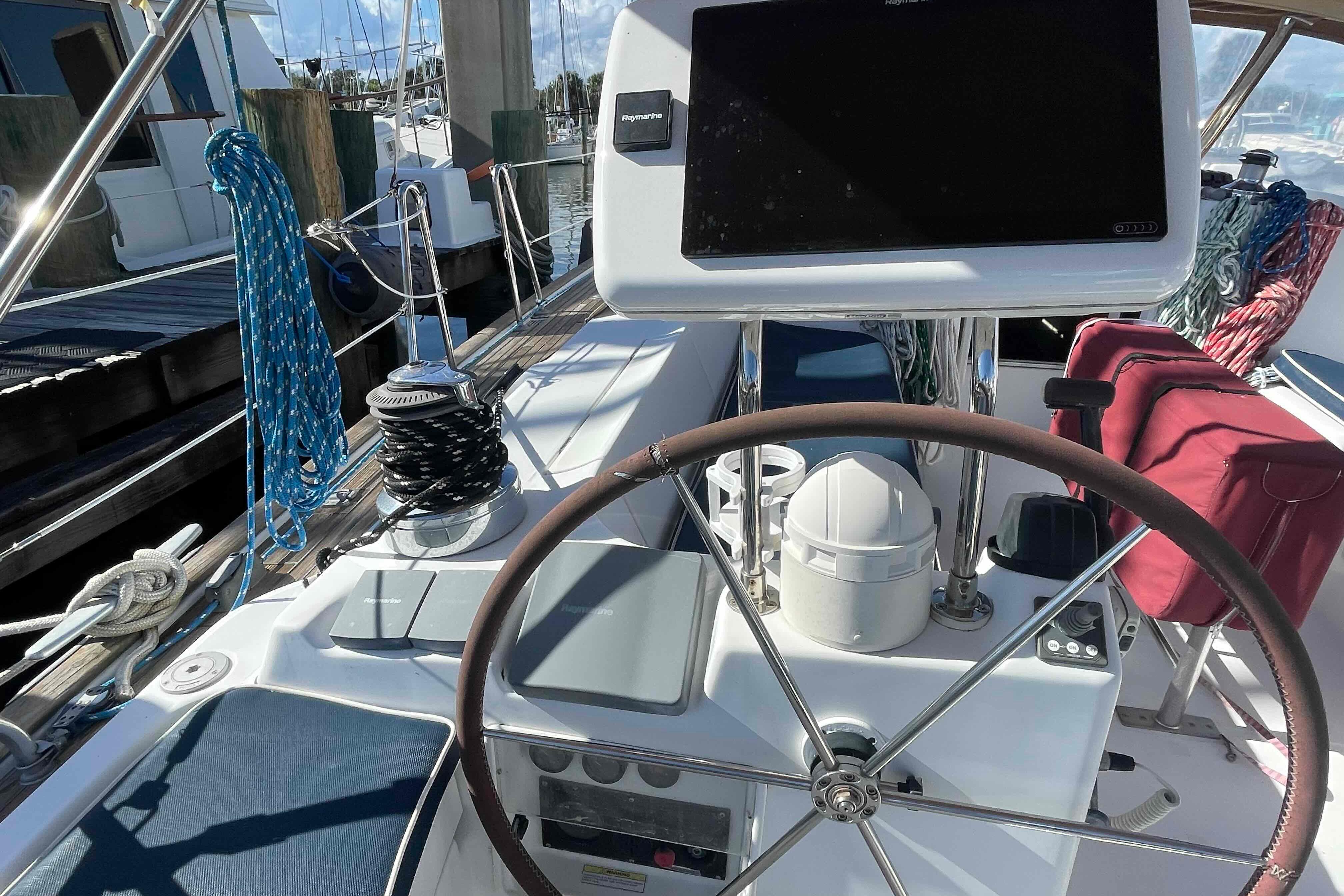 Cockpit of 2004 Beneteau Oceanis 473 sailboat with steering wheel and navigation equipment.