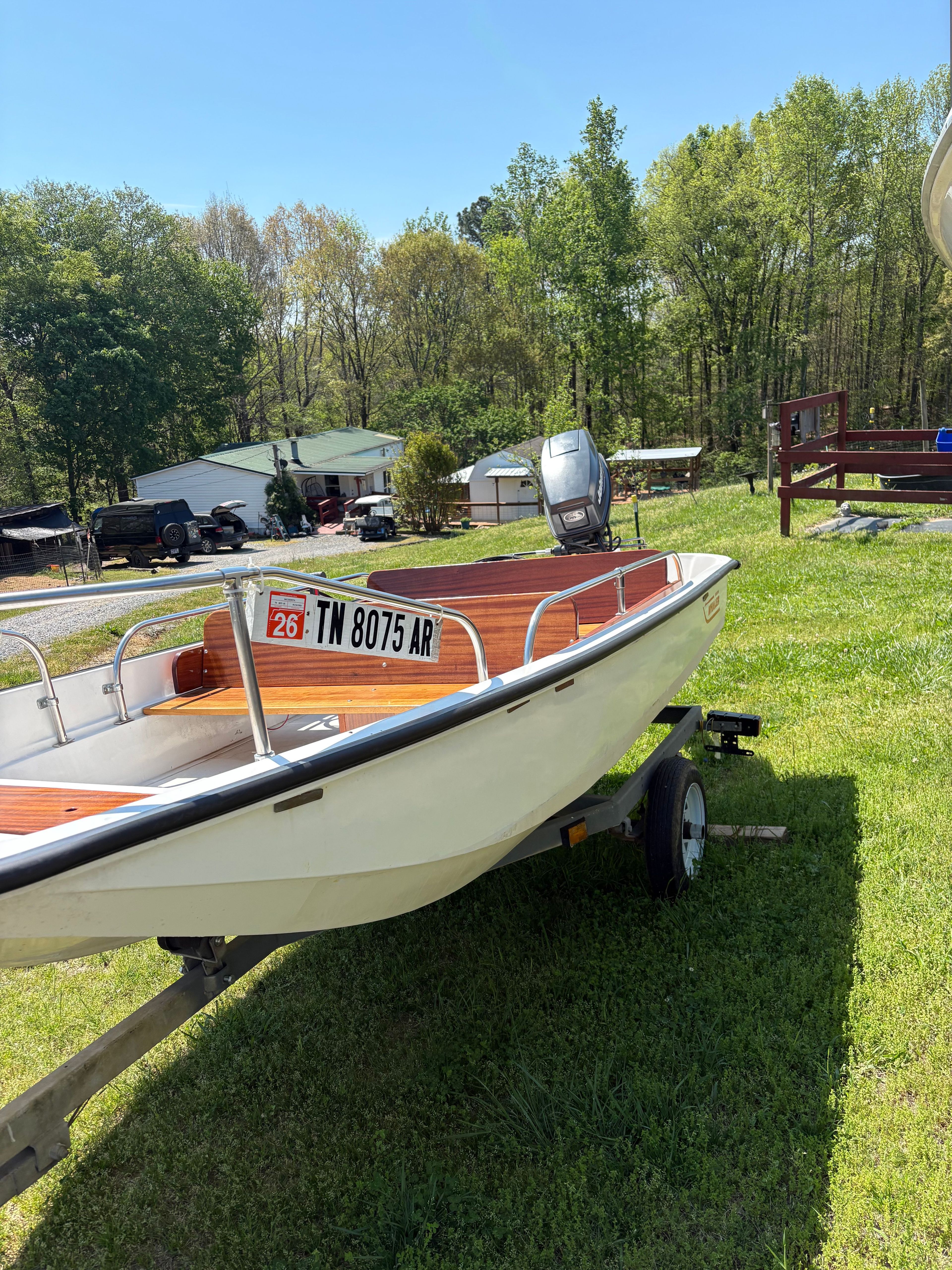 1977 Boston Whaler 13 boat on trailer in grassy area.