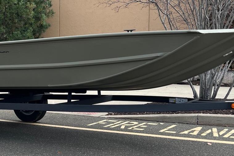 2026 Tracker Grizzly 1654 T Sportsman boat on trailer in parking lot.